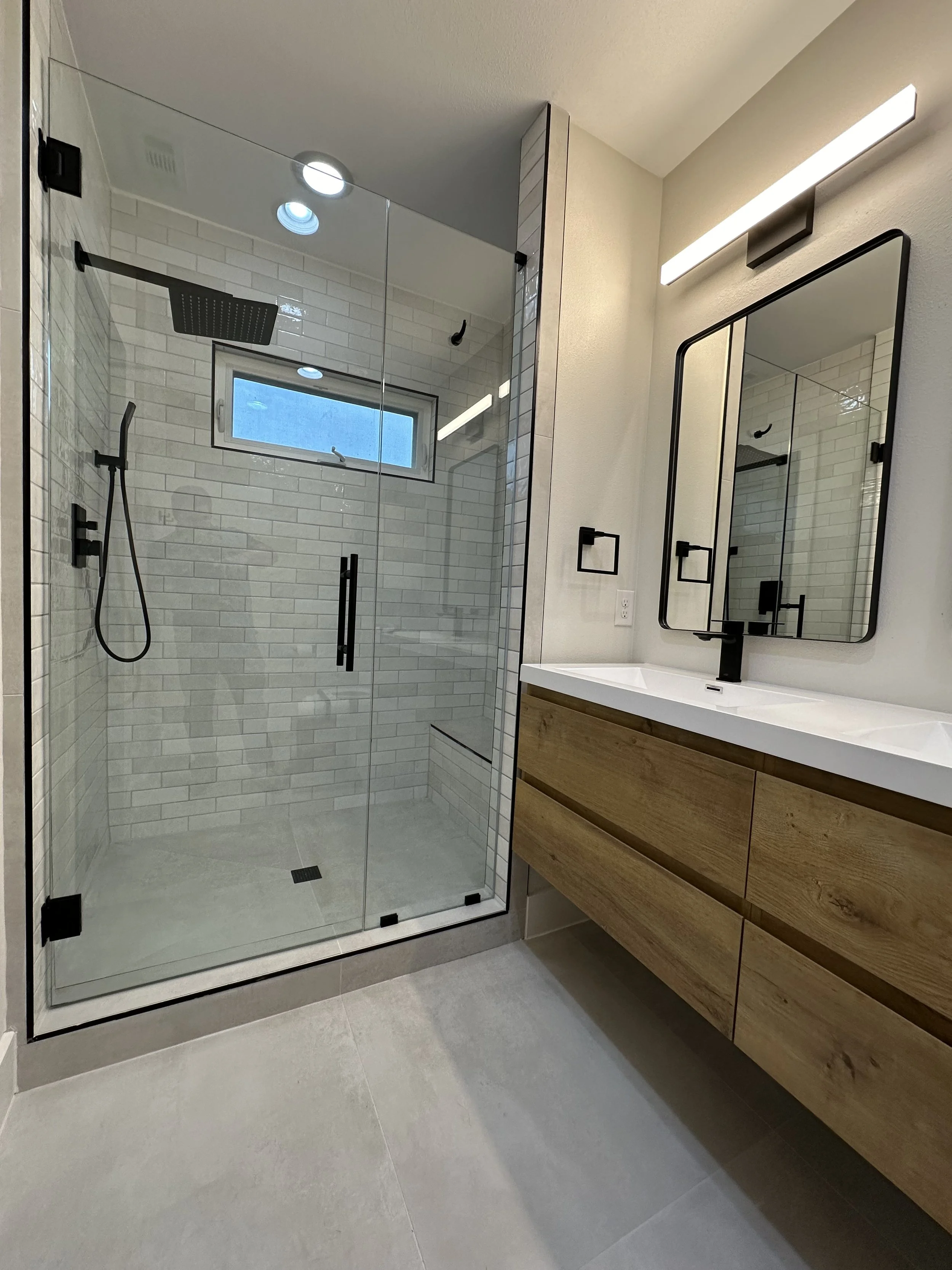 Beautiful white, grey and black tub conversion remodel by Proline Contracting in San Antonio, Texas.