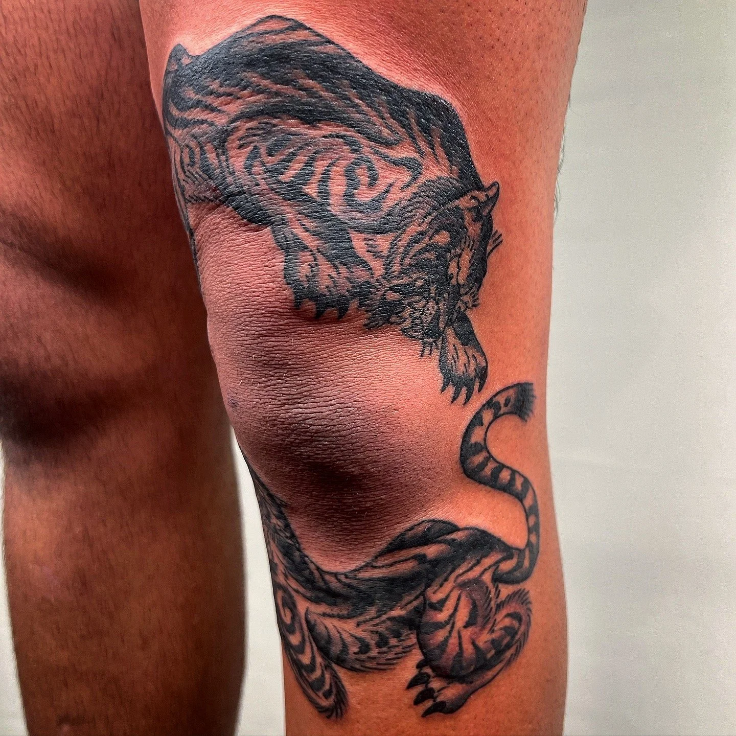 Tattoo of a tiger on a person's thigh.