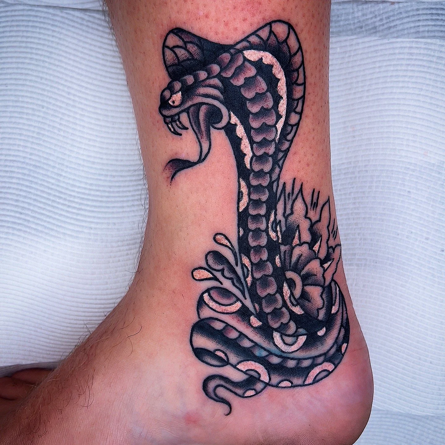 Black and gray snake tattoo on side of person's torso and waist.
