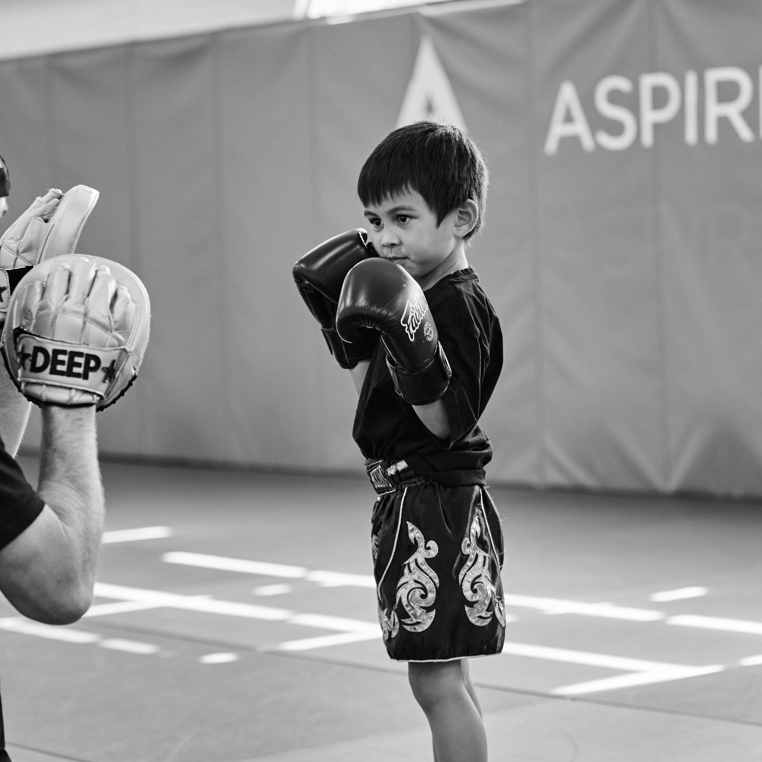 Aspire MMA gym, exchanging a high-five. Kids self-defence, boxing, MMA, UFC, boxing, BJJ, grappling, jiu jitsu, wrestling, self-defence, kick boxing, fitness, community. little legends class