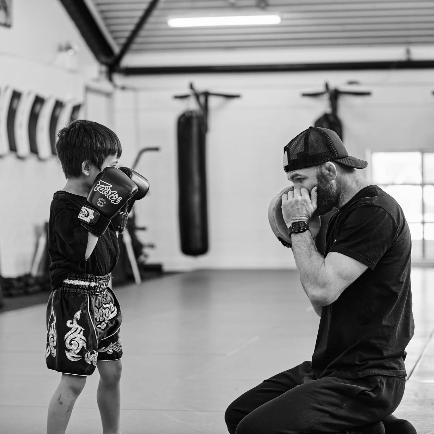 Aspire MMA gym, coach and student doing a lesson. Kids self-defence, boxing, MMA, UFC, boxing, BJJ, grappling, jiu jitsu, wrestling, self-defence, kick boxing, fitness, community. little legends class
