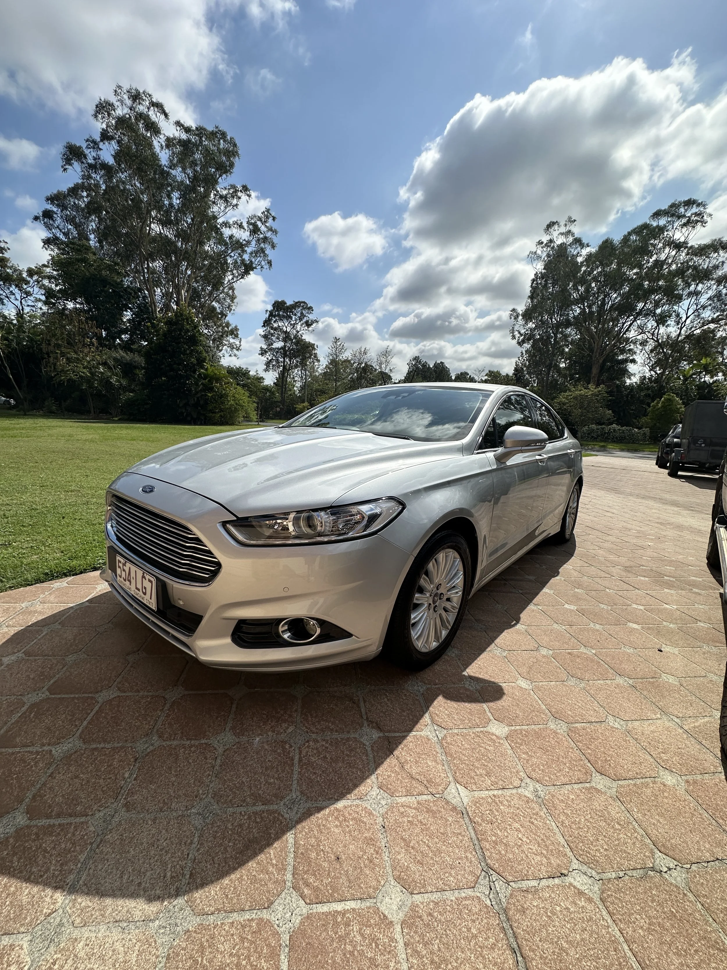 Silver Ford sedan with a pristine exterior finish after a professional detailing service by Steam & Gleam.