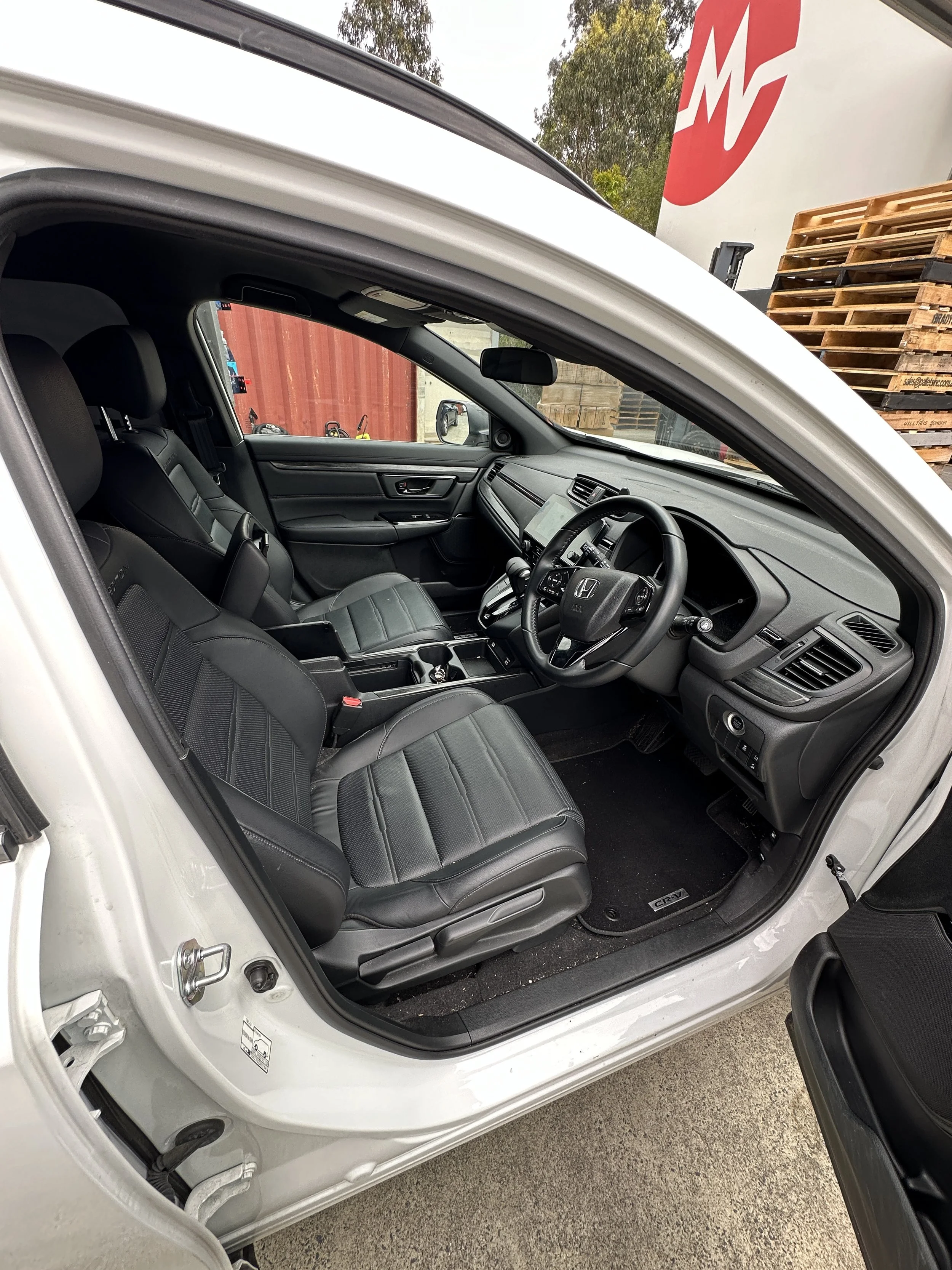 Detailed interior of a white Honda SUV, showcasing clean leather seats and a spotless dashboard after Steam & Gleam’s professional detailing service.