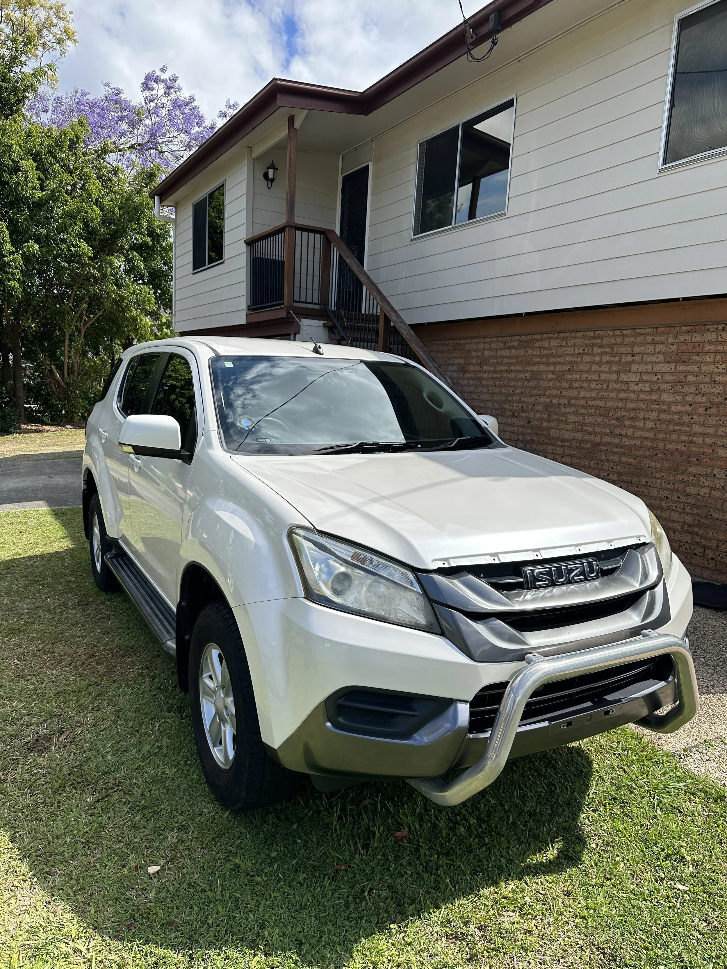 A silver Isuzu SUV with a spotless exterior after Steam & Gleam’s detailing service, featuring a clean and polished finish.