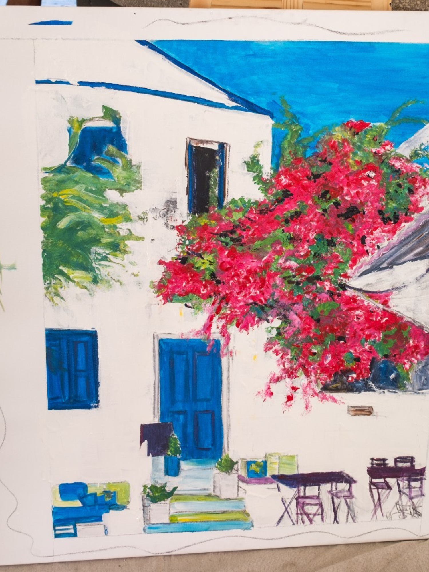 Painting of a white Mediterranean style building with blue doors and windows, and a staircase leading to a blue door, surrounded by a large pink flowering tree and green plants, with blue sky above.