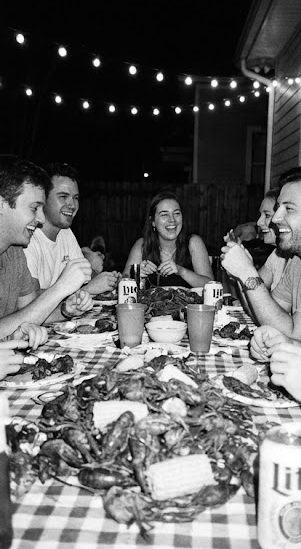 FRIENDS IN A BACKYARD ENJOYING CRAWFISH