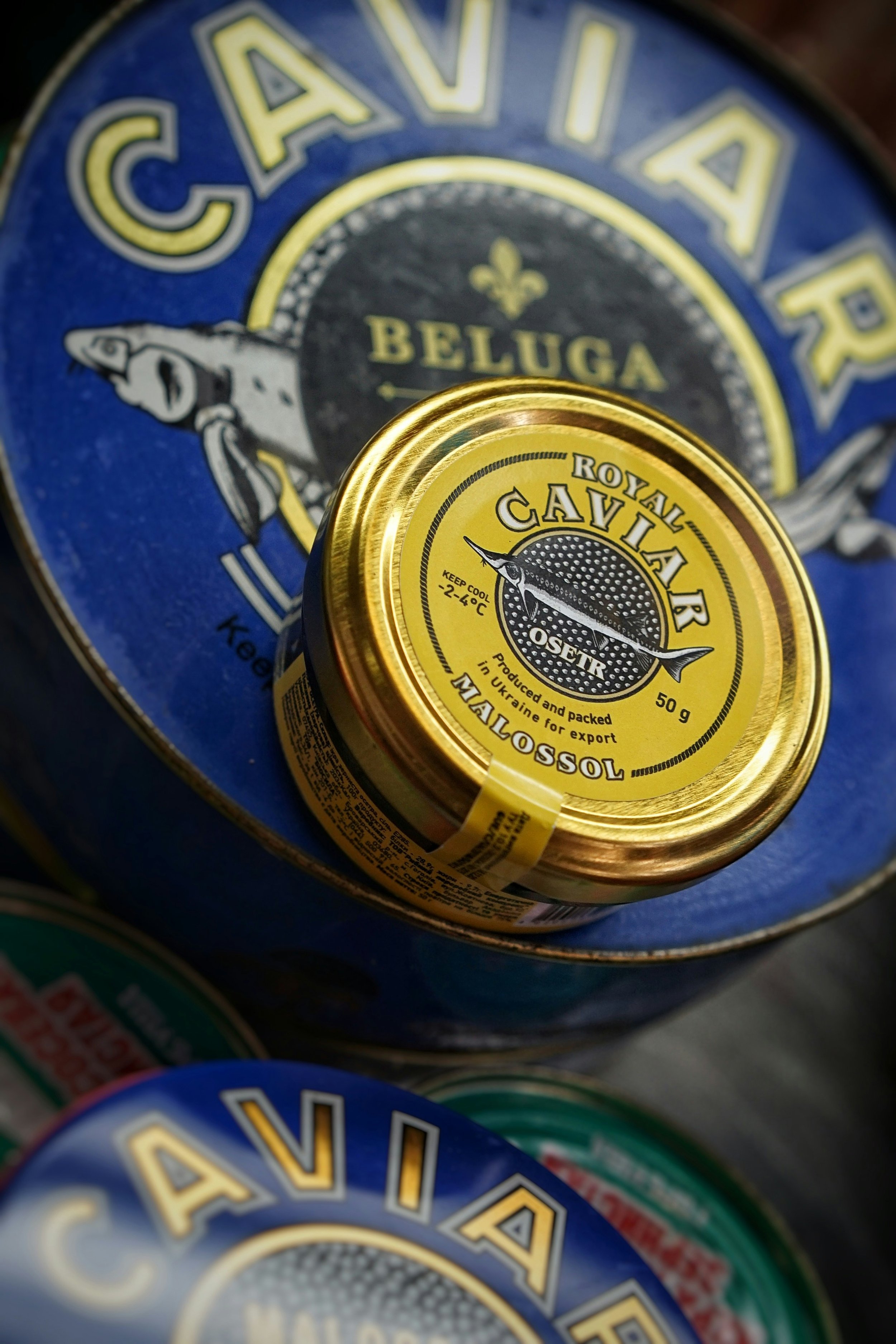a small jar of royal caviar on top of a blue surface