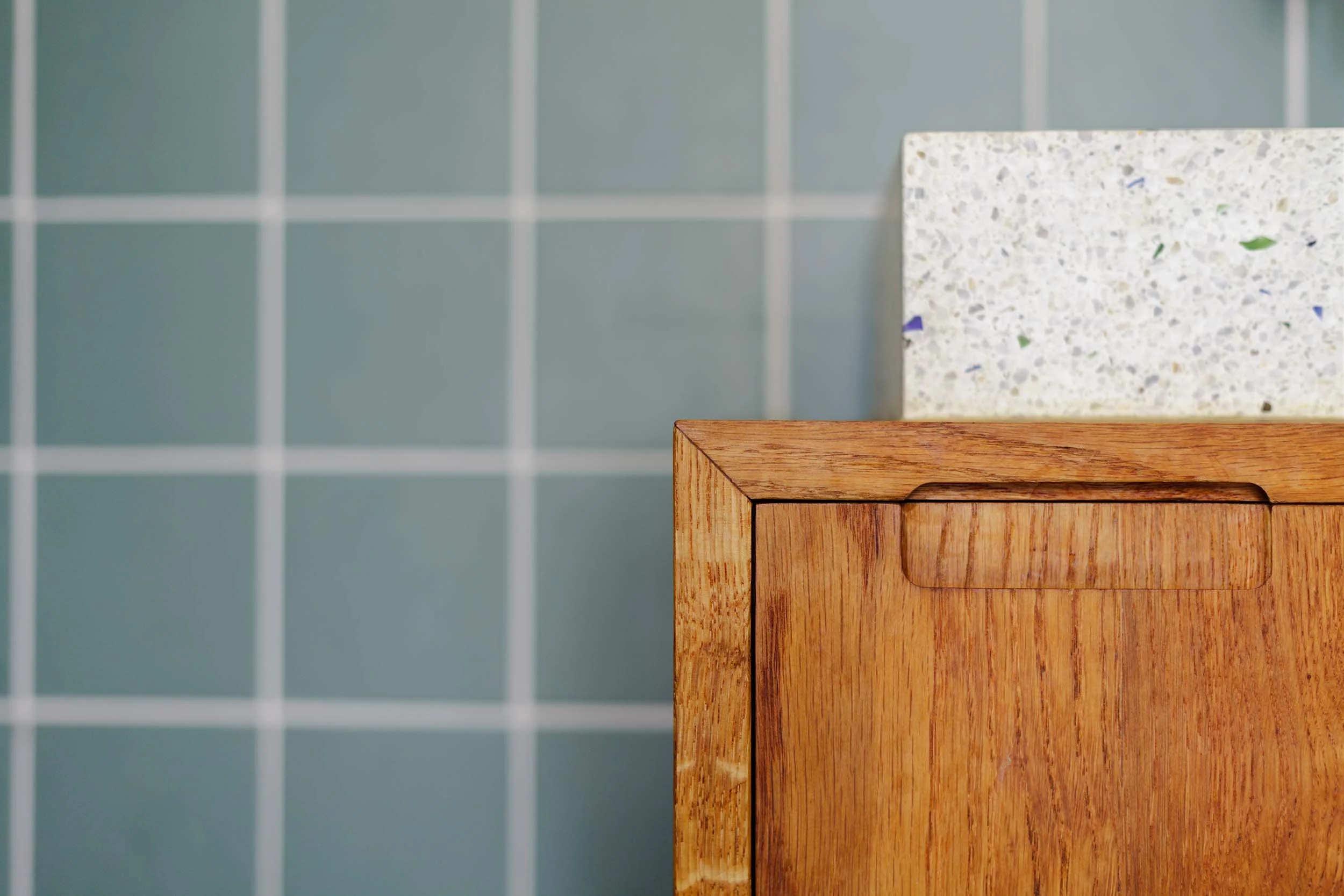 Close-up van ingefreesde greep op toiletmeubel met terrazzo wasbak