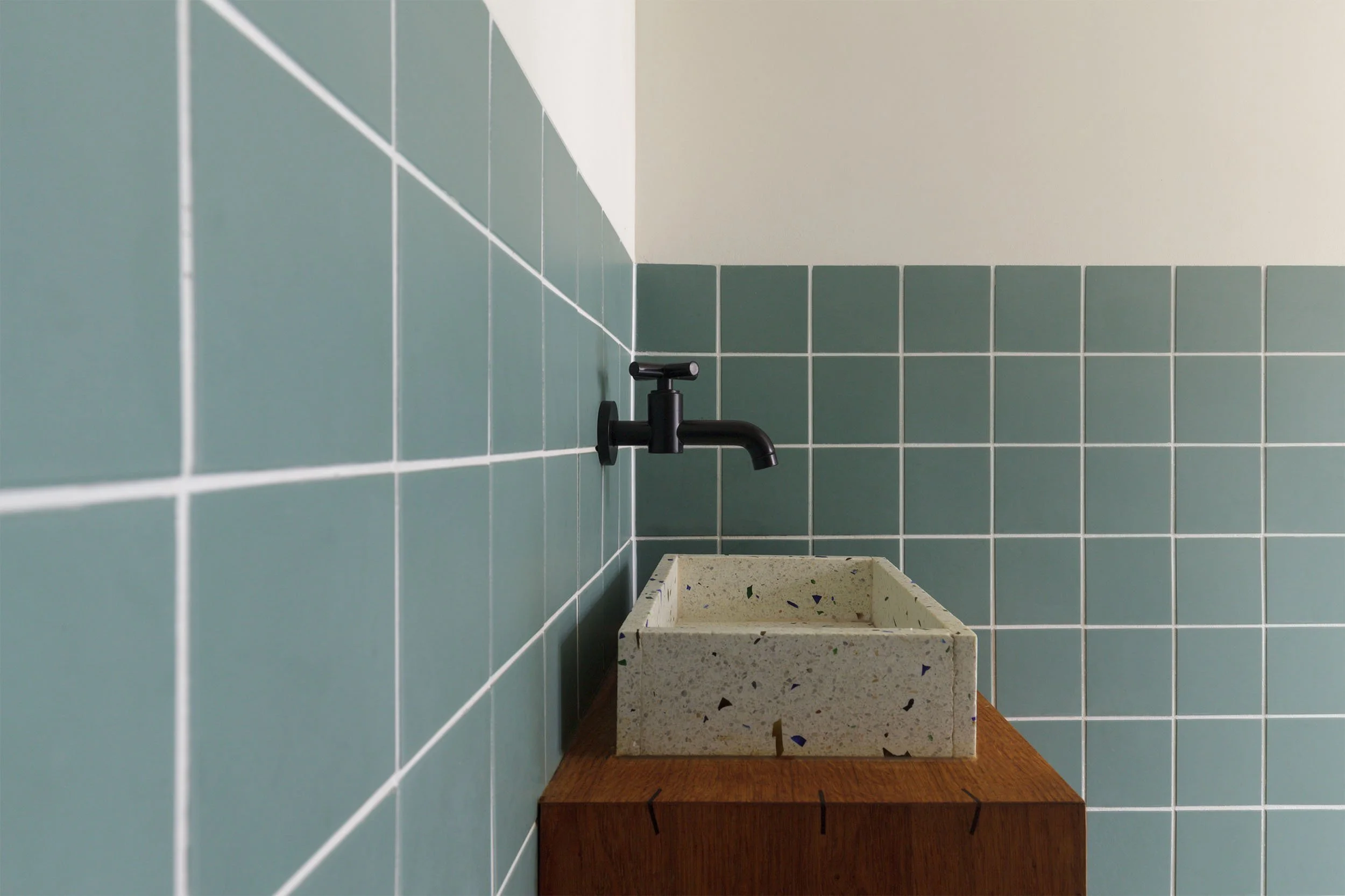 Dornbacht Tara tapkraan zwart boven terrazzo wasbak in toilet