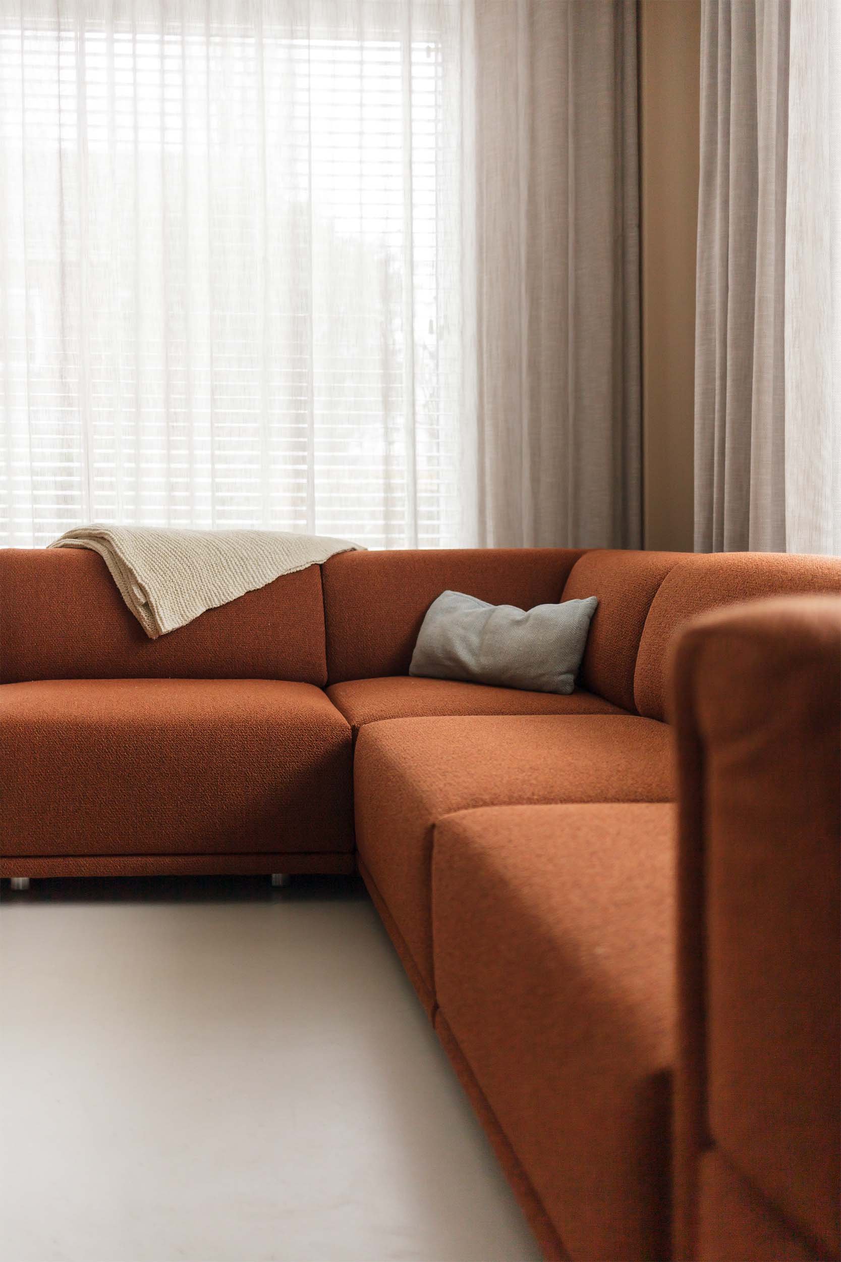 Grote rode designbank met grijs kussen