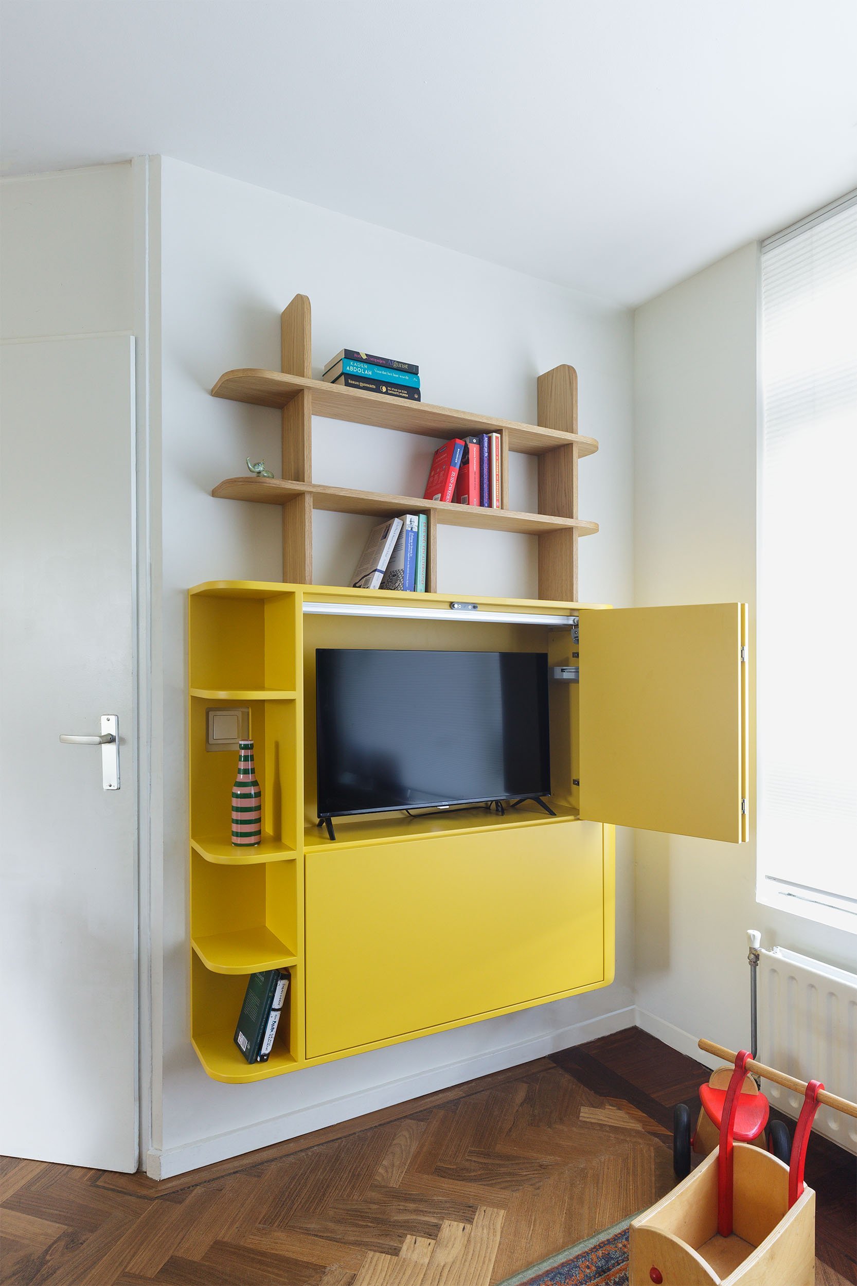 televisie in wandmeubel met vouwdeuren