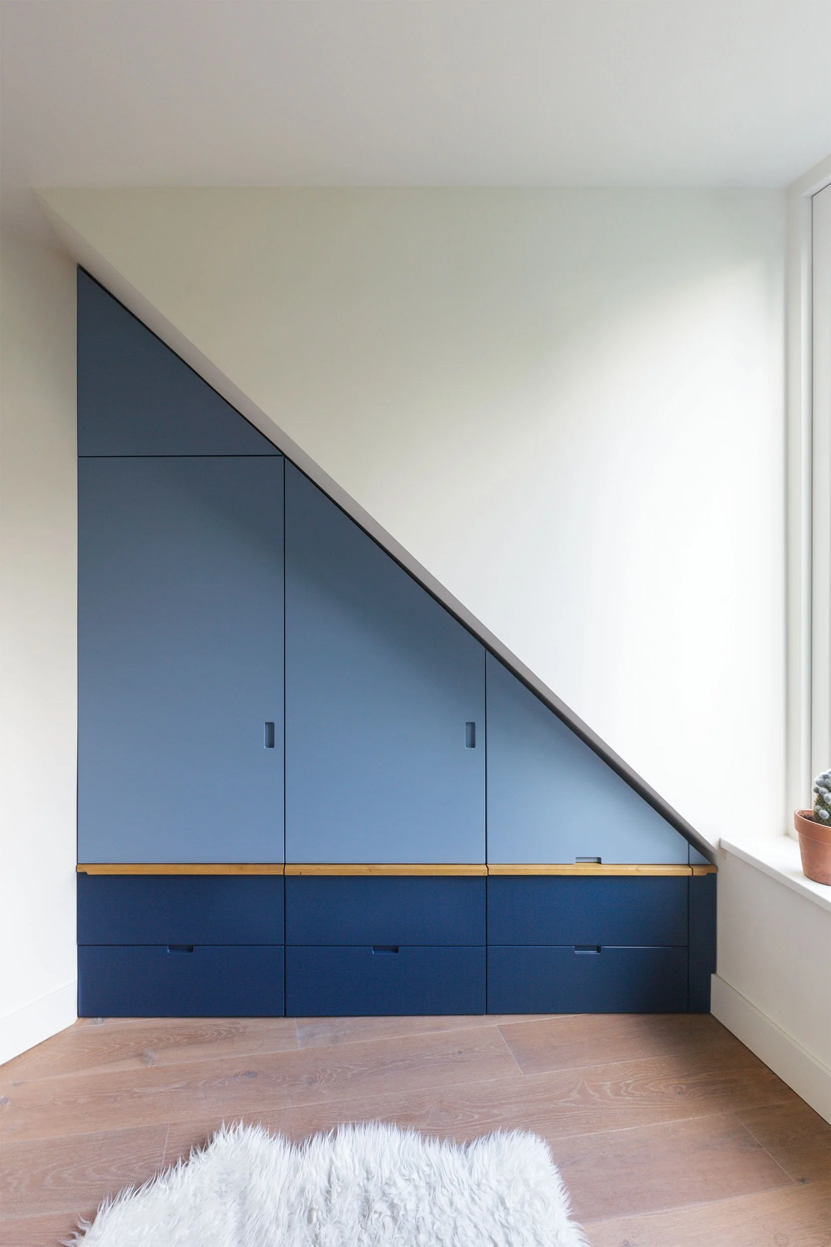 Kast onder dakkapel met eikenhouten greep op slaapkamer