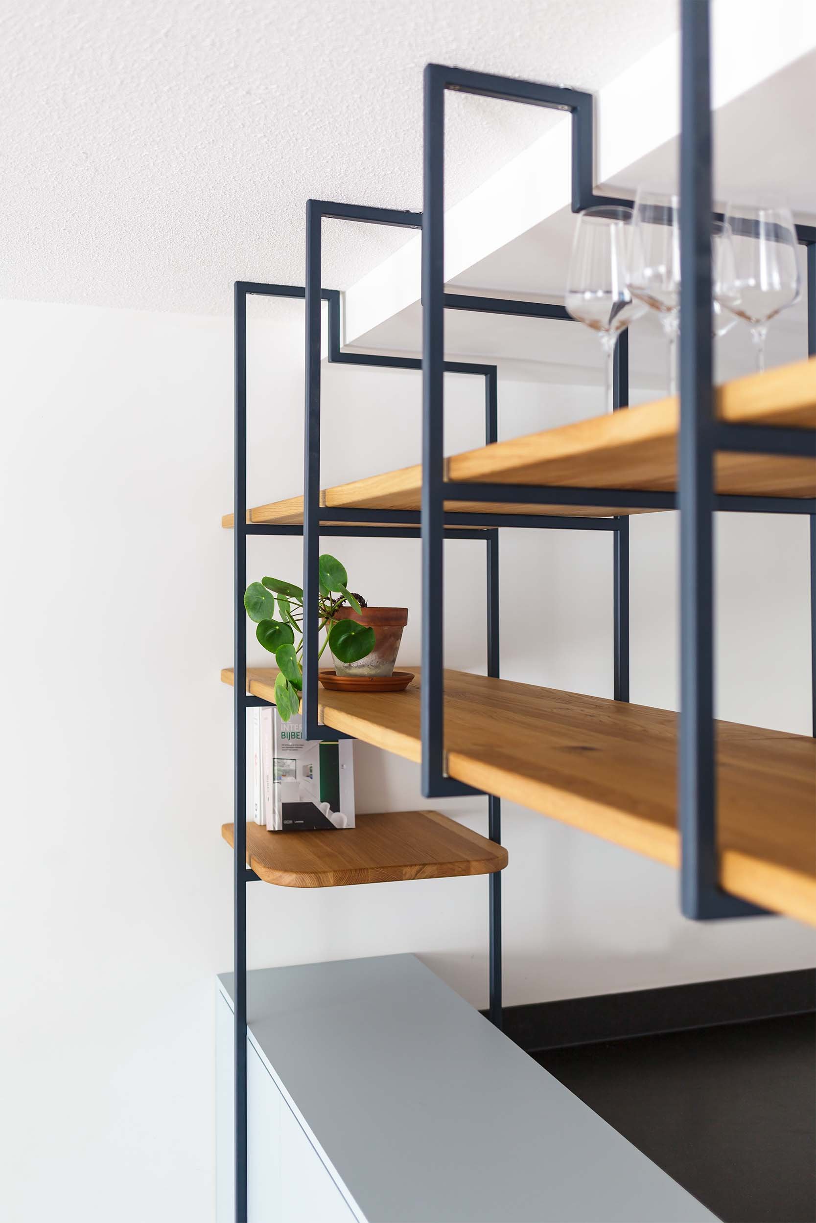 Stalen frame met eikenhouten planken met glazen in maatwerkkeuken