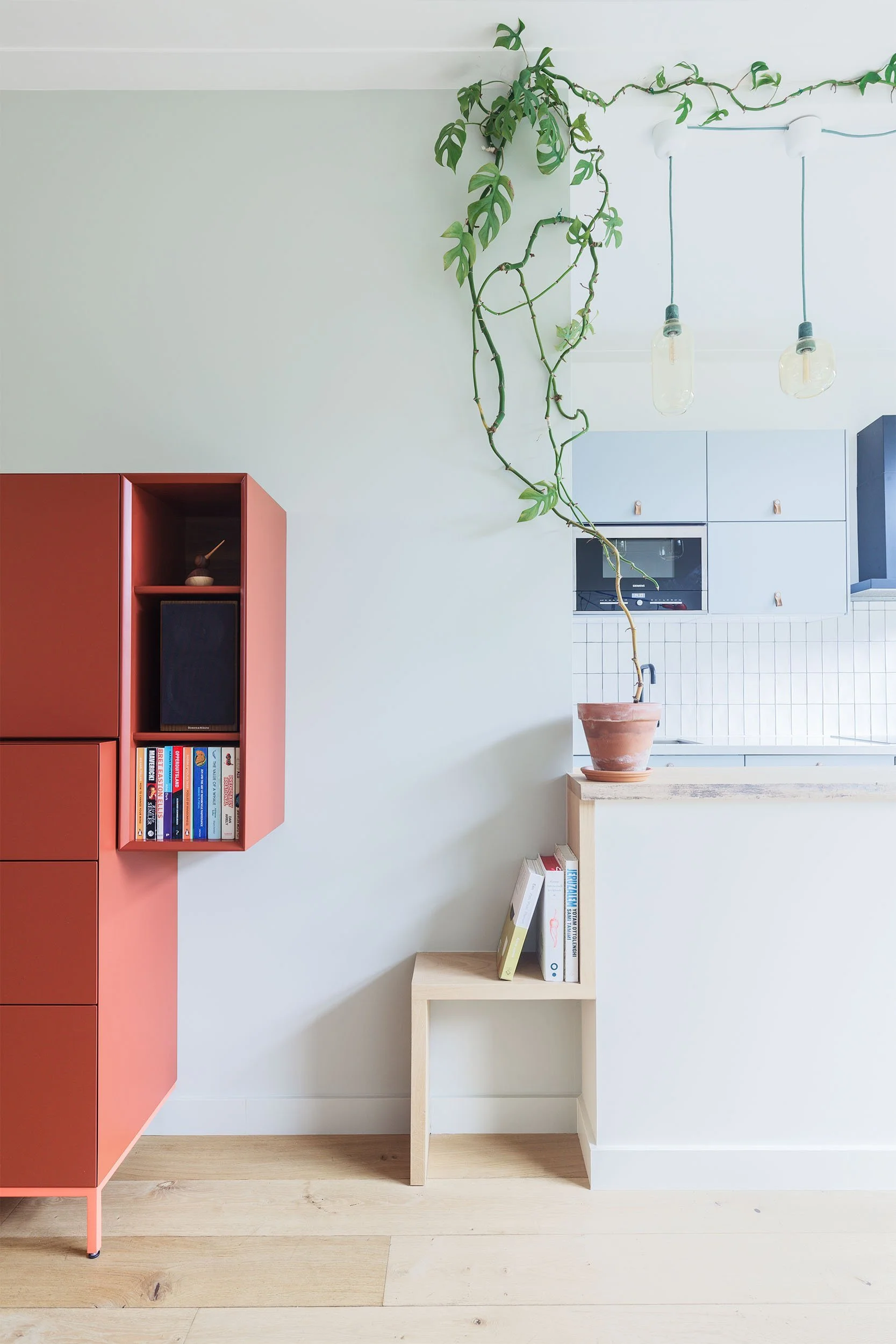 Wandmeubel en bijpassende houtenkeukenbar met normann copenhagen amp lamp