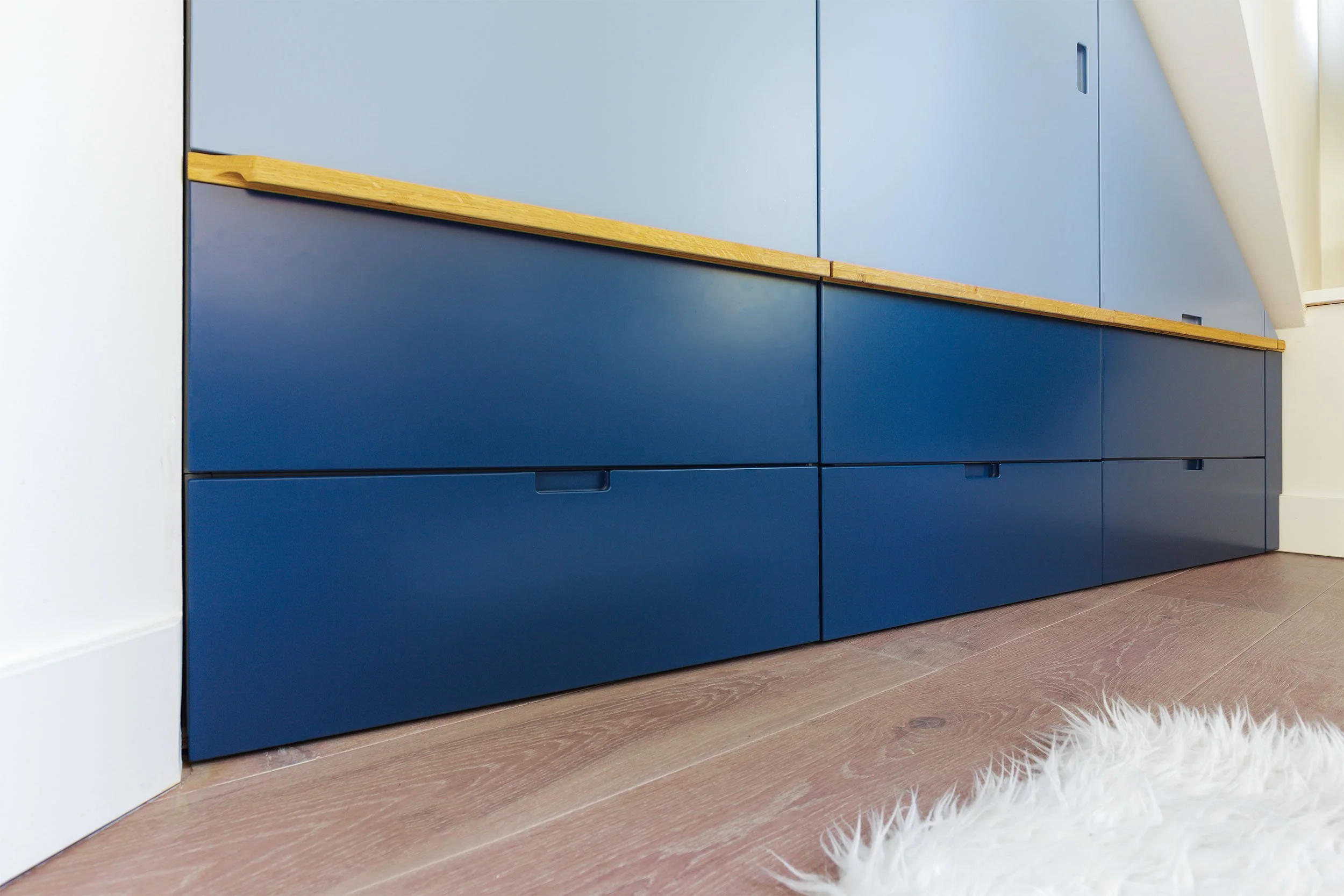 Close-up van donker blauwe ladefronten met eikenhouten greep