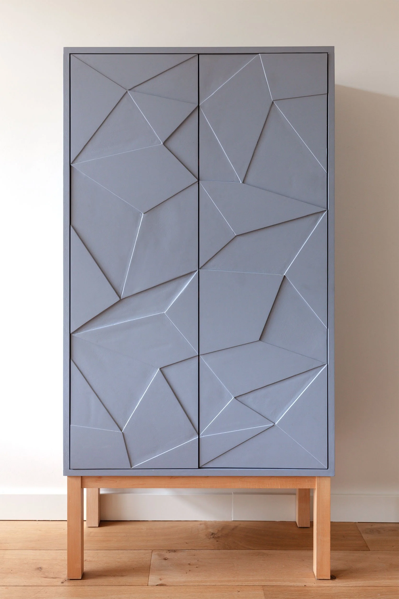 Highboard met geometrische deuren op essenhouten onderstel