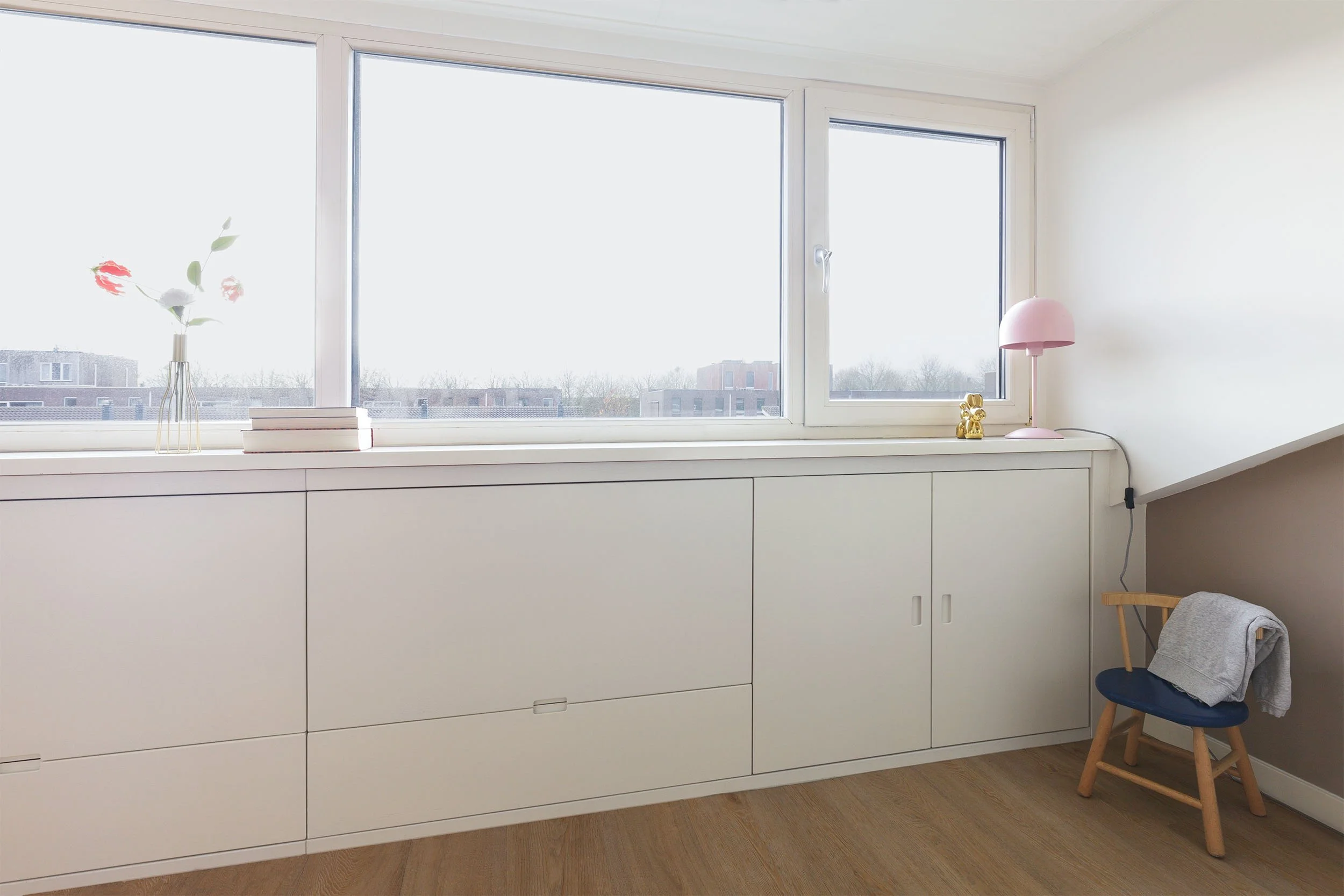 Kast onder schuin dak op zolder met houten vloer