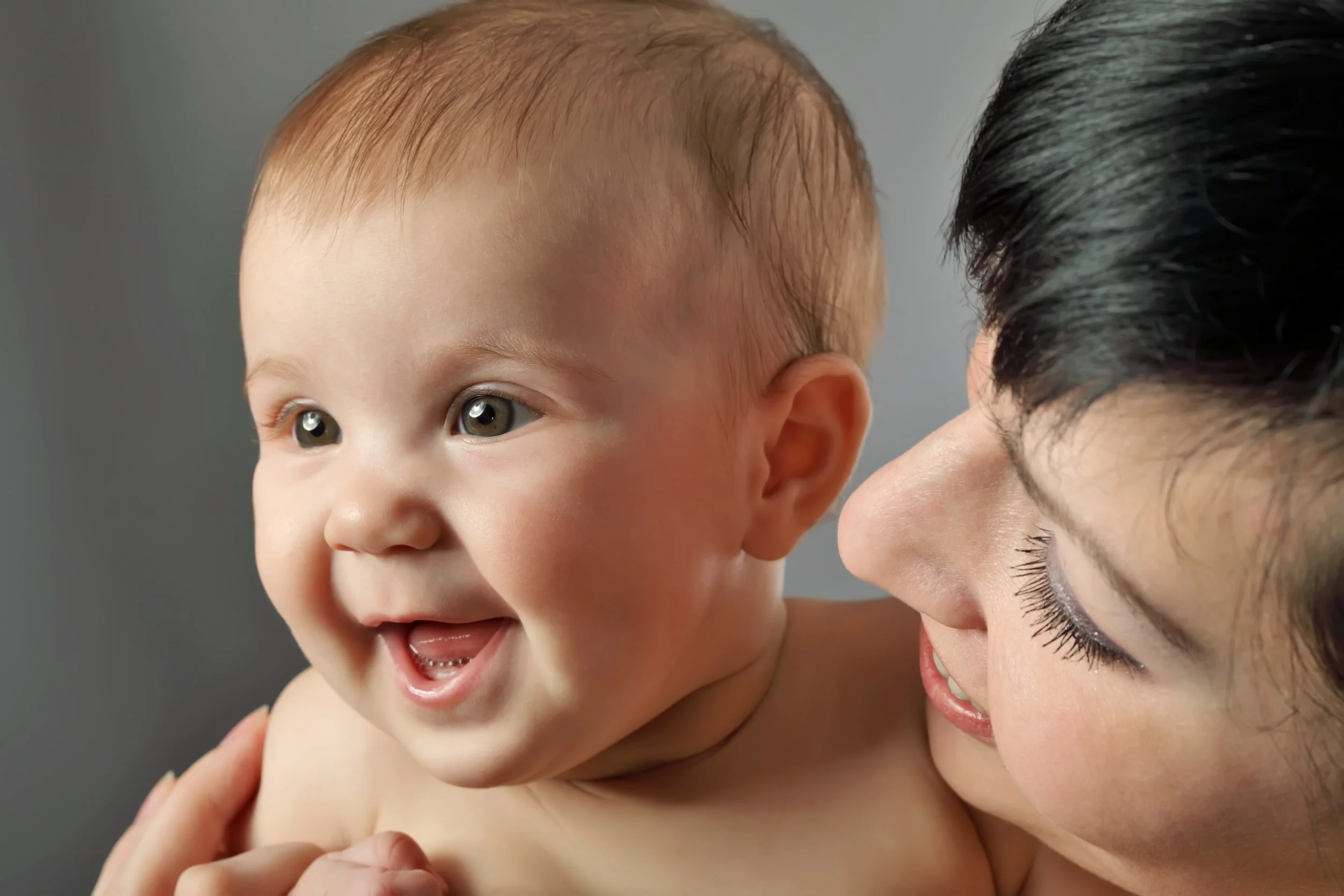 Young baby being held and smiling parents support services lactation