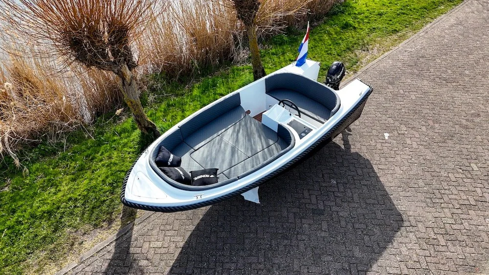 Zwart-witte Admiral 525 sloep van boven bekeken op de kant langs het water