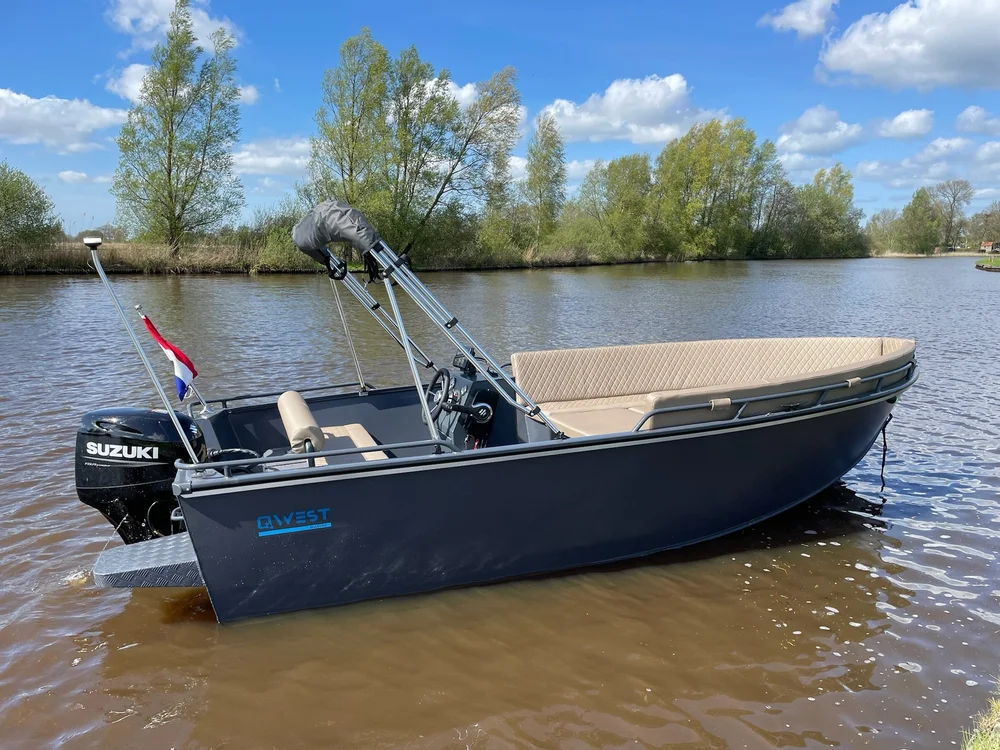Donkere Qwest R535 aluminium sloep met biminitop varend op het water