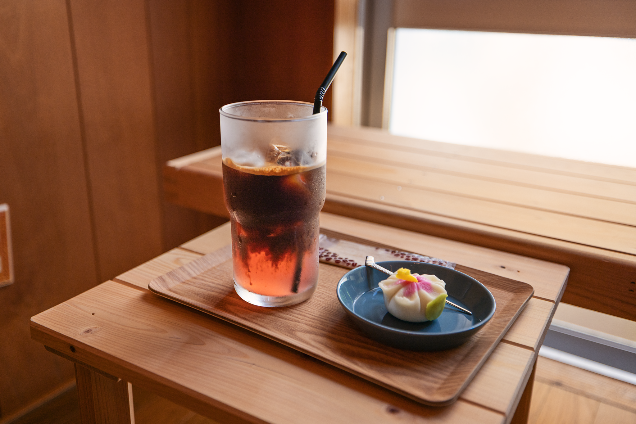 Coffee Kashi Chatan Hibiscus Espresso Tonic and Hibicus Wagashi on top of wooden furniture