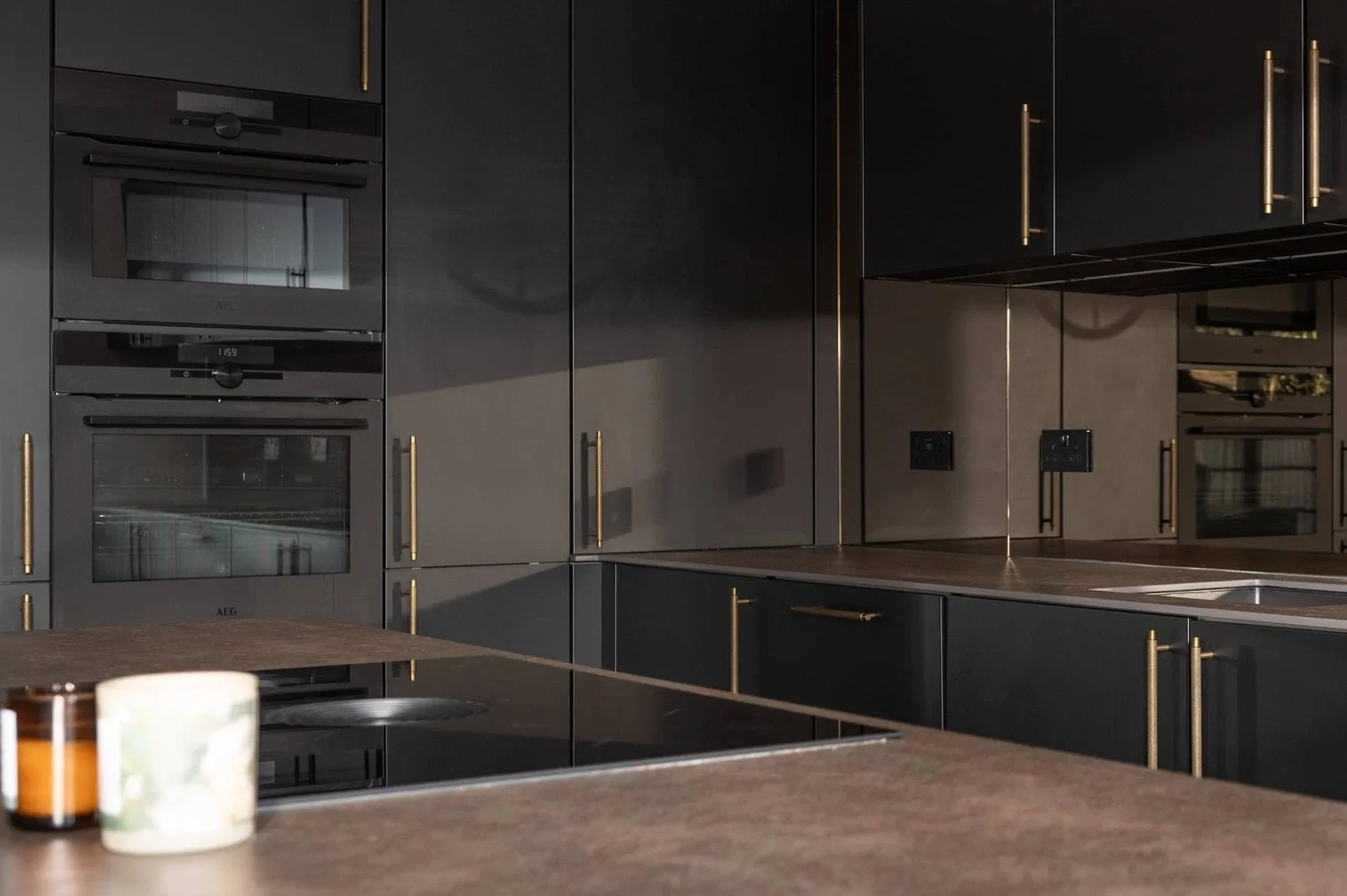 mirrored splashback and dark stone worktop