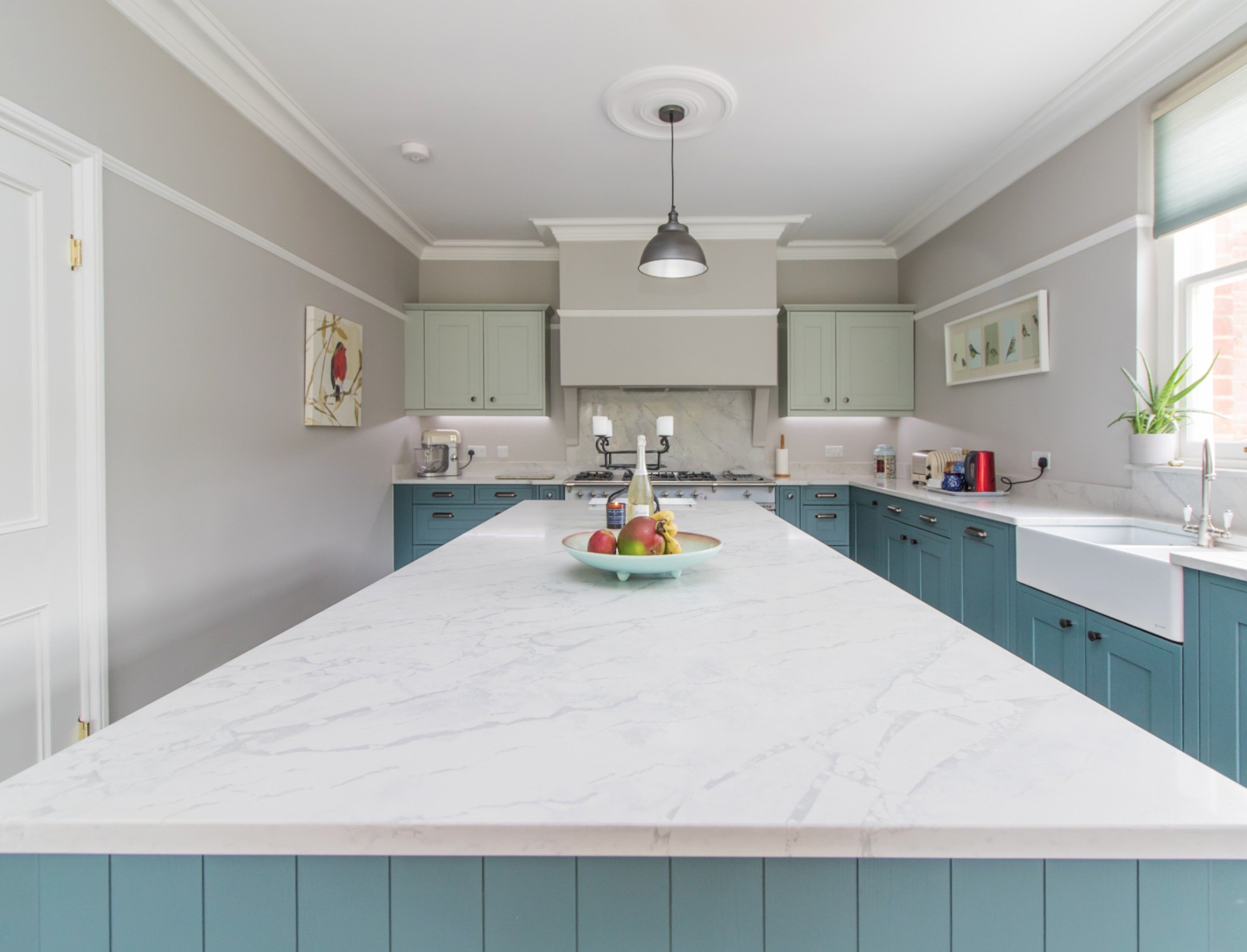 white quartz worktop in blue shaker kitchen