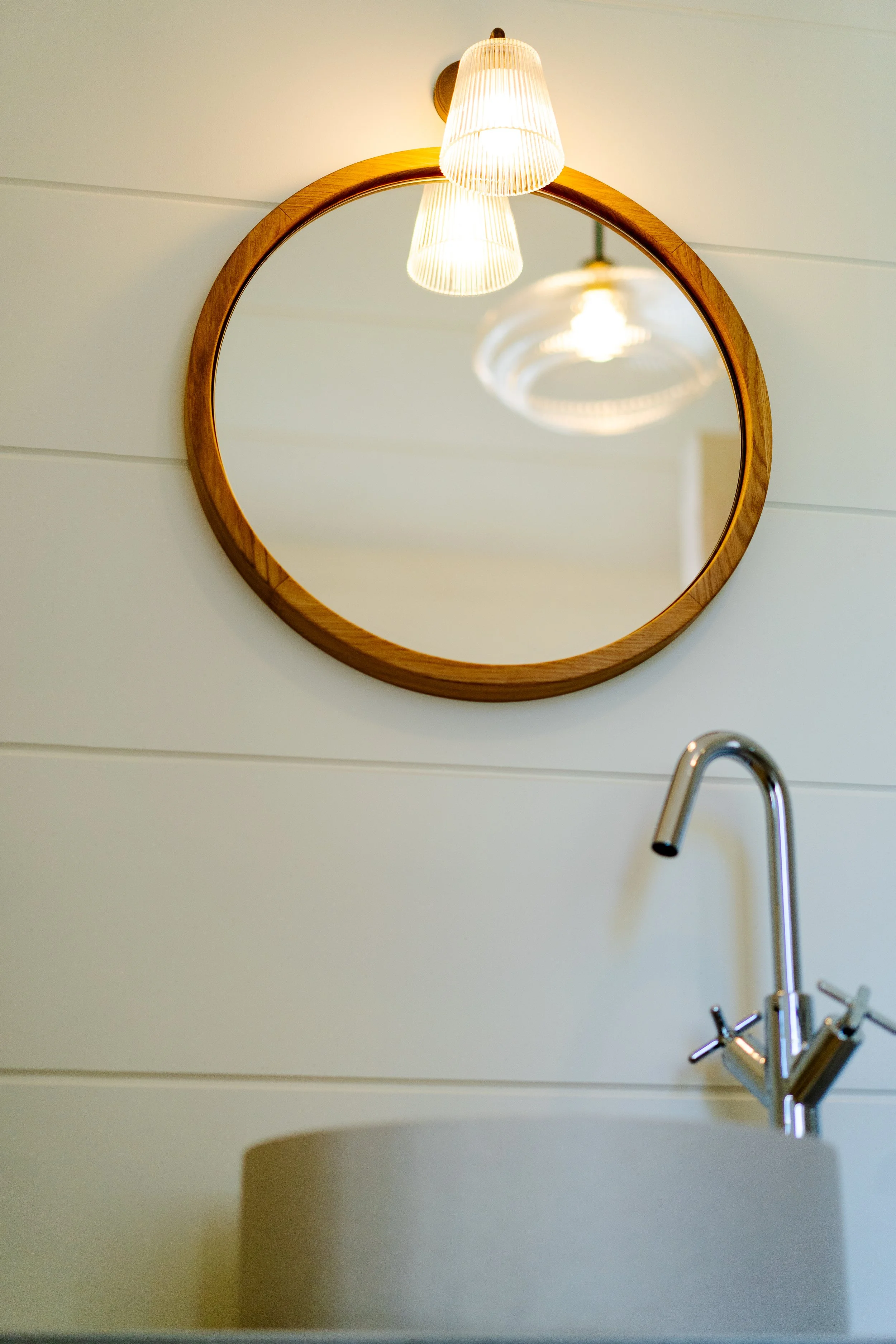 Lighting that accents the green and custom bespoke bathroom with Astro Borgo light fittings installed in the pannelling . 