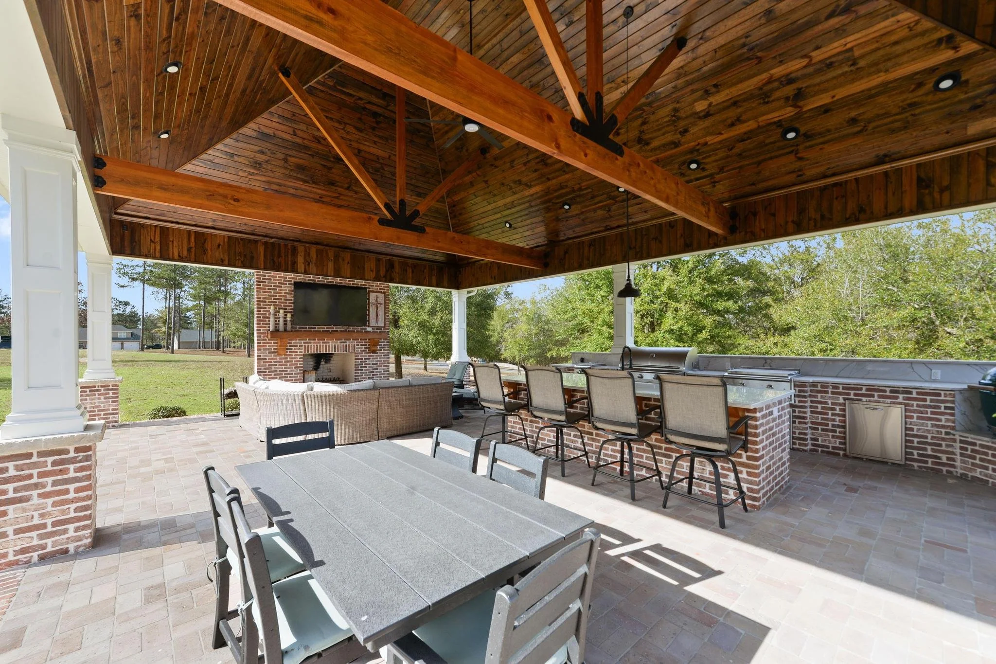 beautiful large brick craftsman style home in lucedale mississippi with 3 bedrooms and 3 and a half bathrooms and a bonus room with 5.1 acres and a large outdoor entertainment area with an outdoor kitchen and large brick fireplace