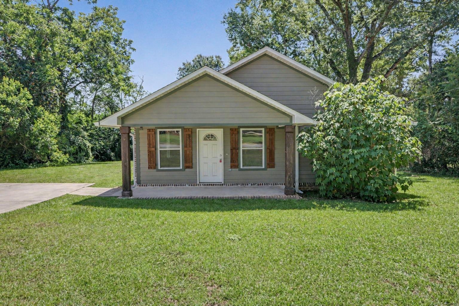 3 bedroom 2 bathroom house located in the city limits of lucedale olive green house  with green front yard brown shutters located in george county mississippi