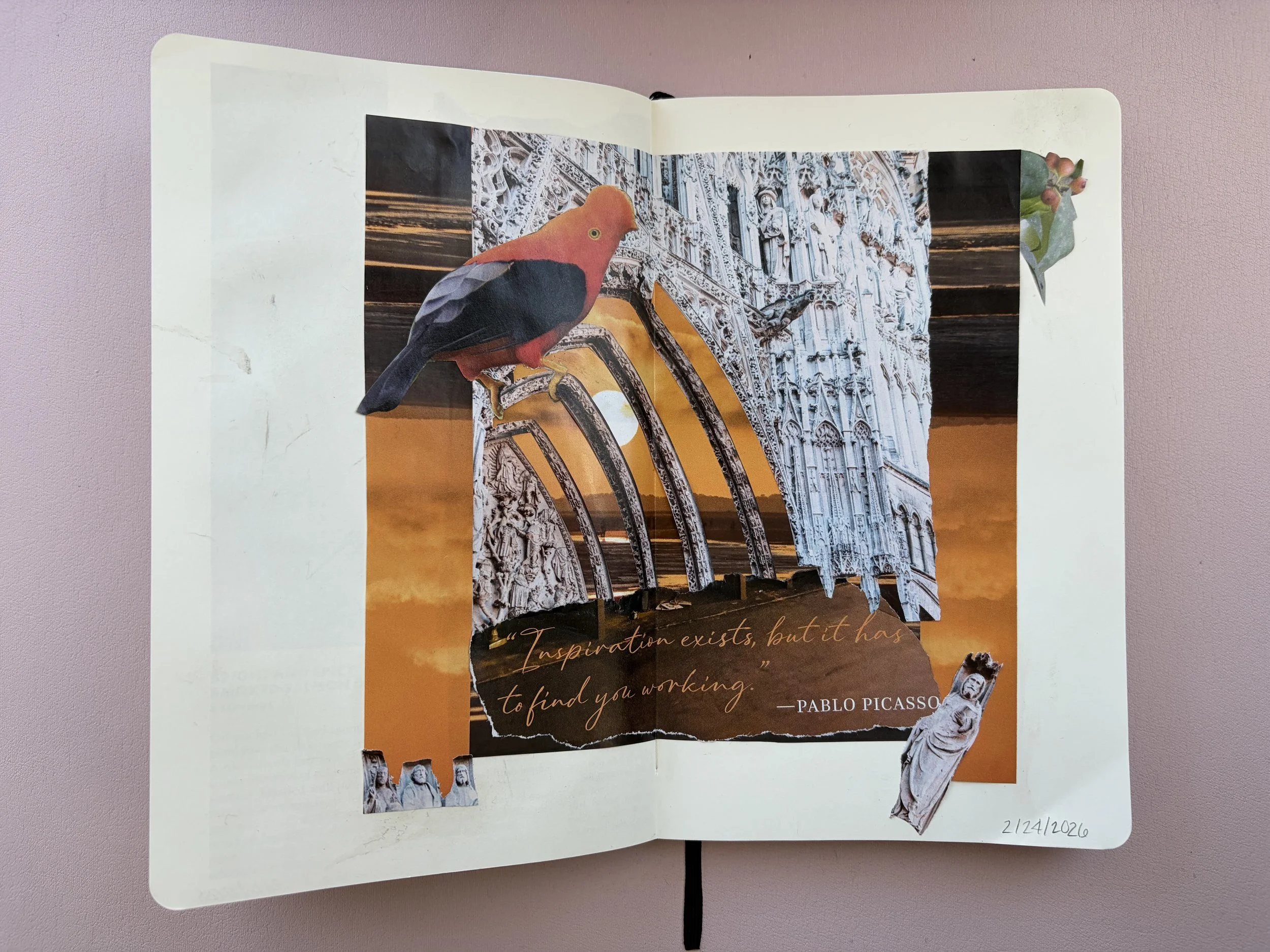 Open scrapbook featuring a collage of a bird, a sunset, and architectural elements with a quote by Pablo Picasso reading 'Inspiration exists, but it has to find you working.' The collage includes torn paper pieces of a cathedral, a sunset, and a bird