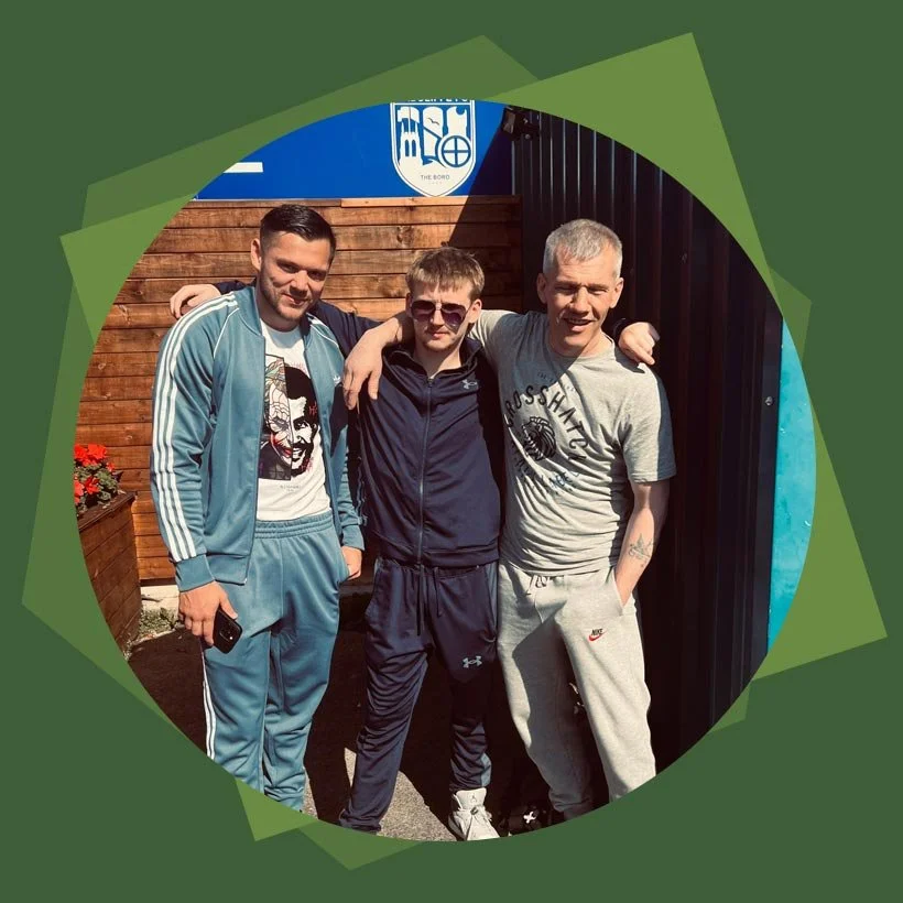 Three men supported through the Dignifi Recovery Programme, standing together smiling