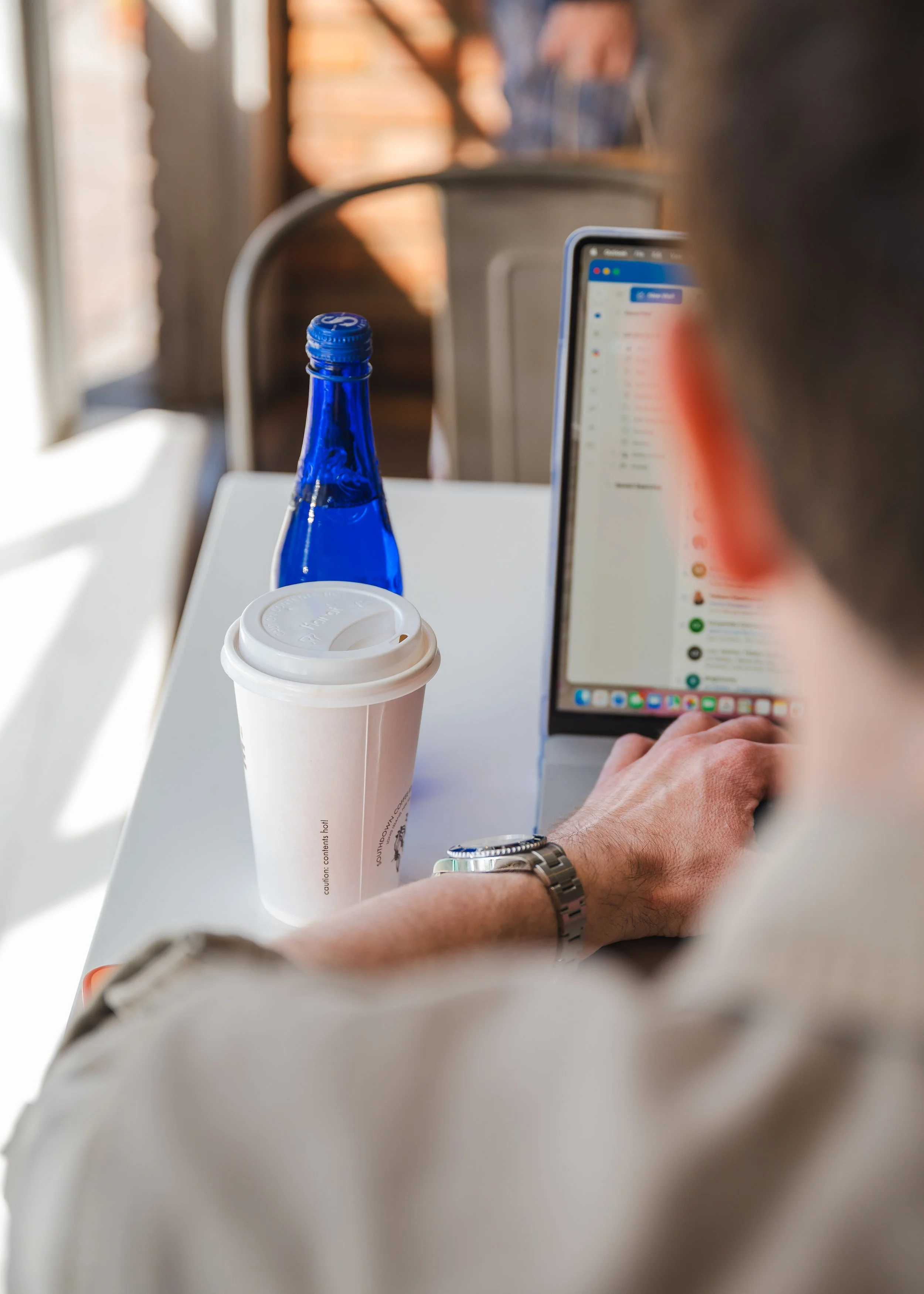 A branding photo of a man working remotely at a coffee shop