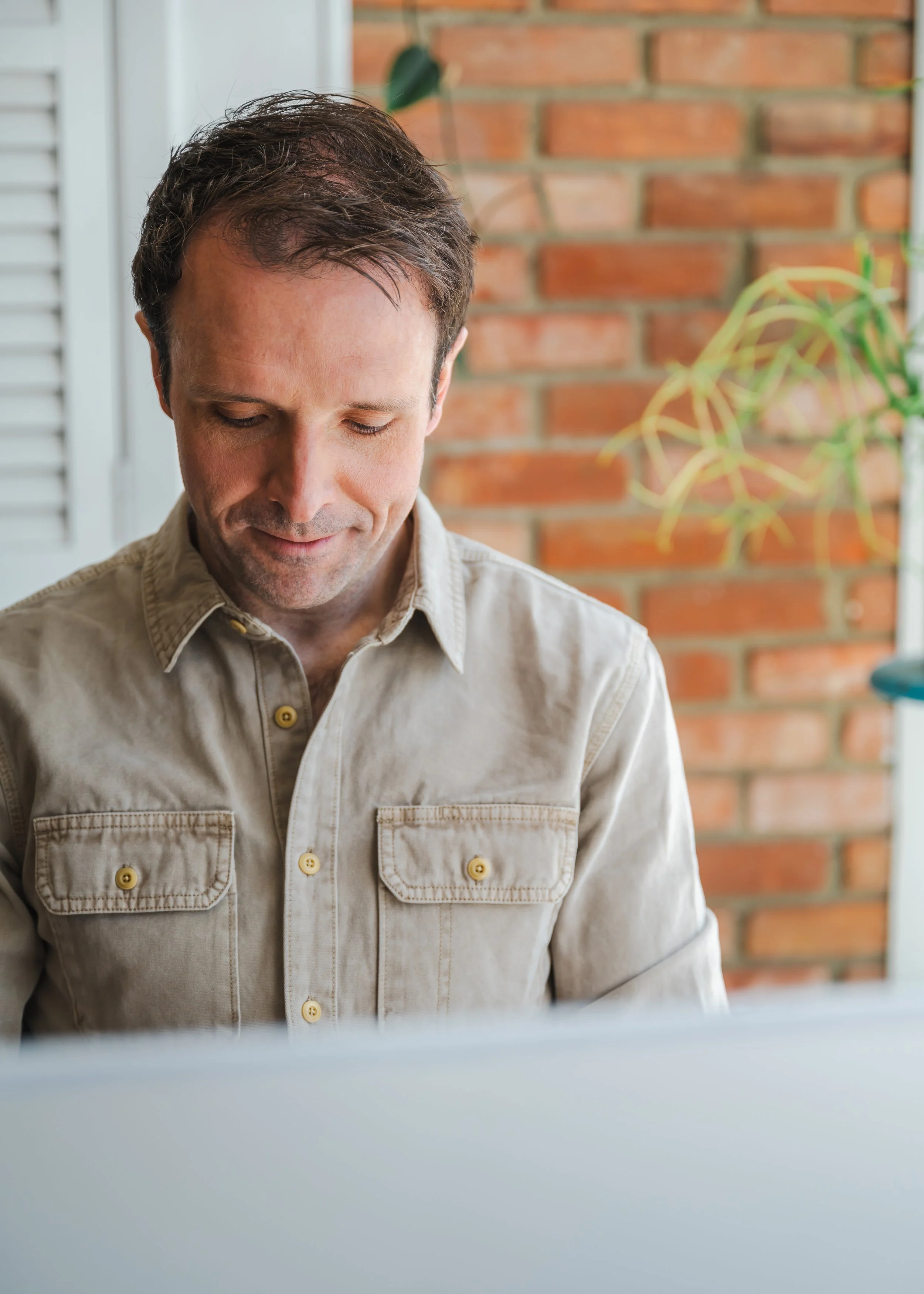 A branding photo of a general counsel in casual wear working remotely at a coffee shop