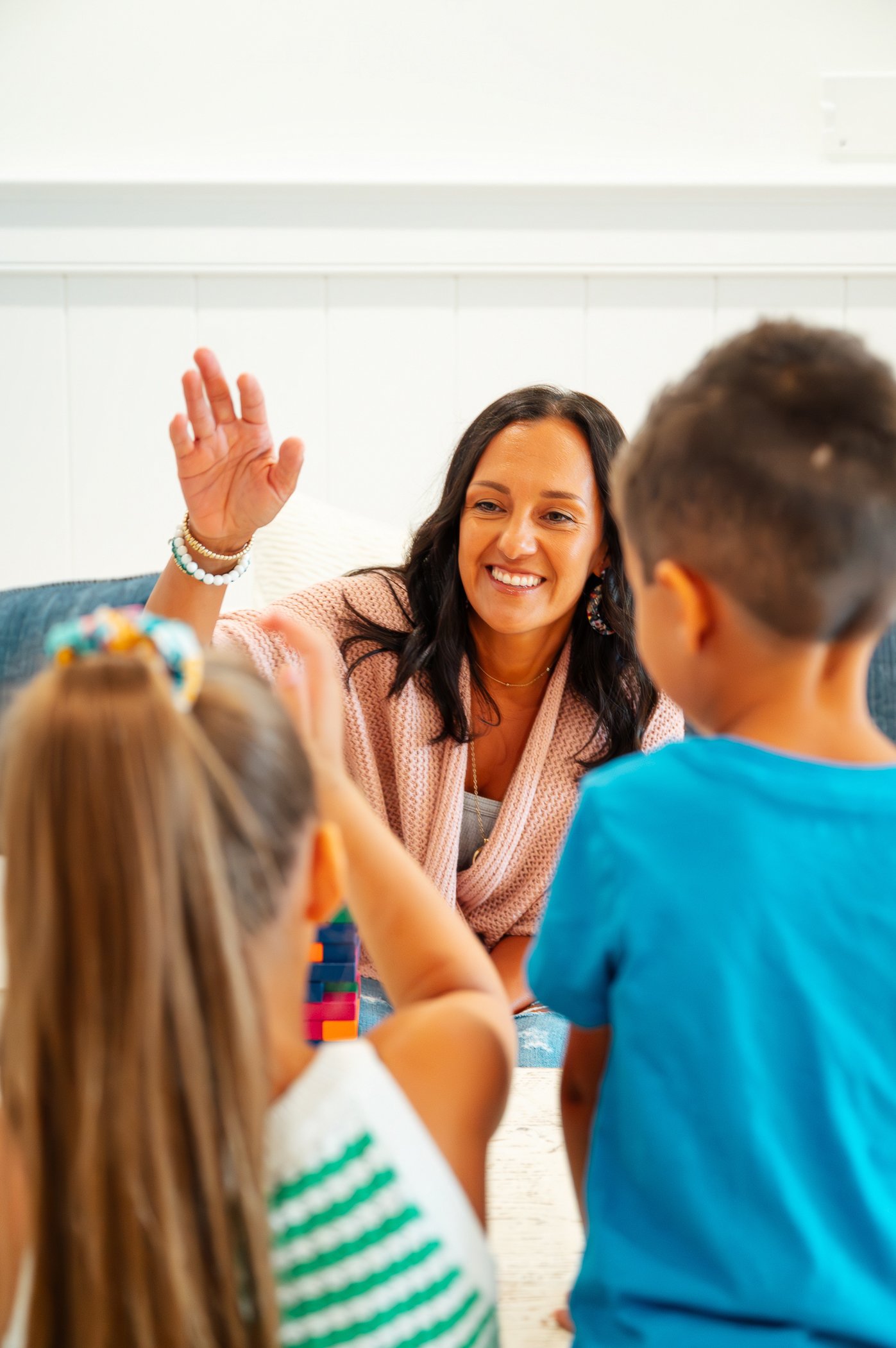 A branding photograph of a therapist in session with two children