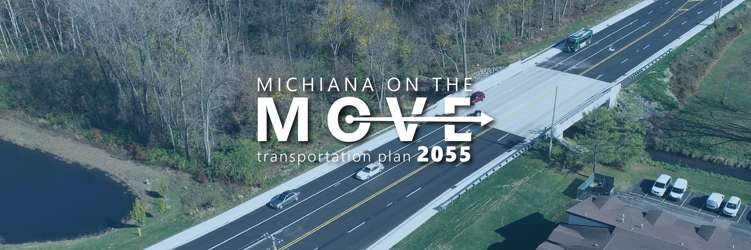 Ariel view of a newly complete road with cars on it and the plan logo overtop.