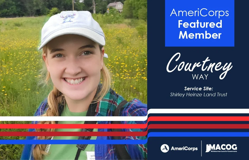 A close up image of Courtney smiling at the camera. She has a hat on and has a field of yellow flowers behind her.
