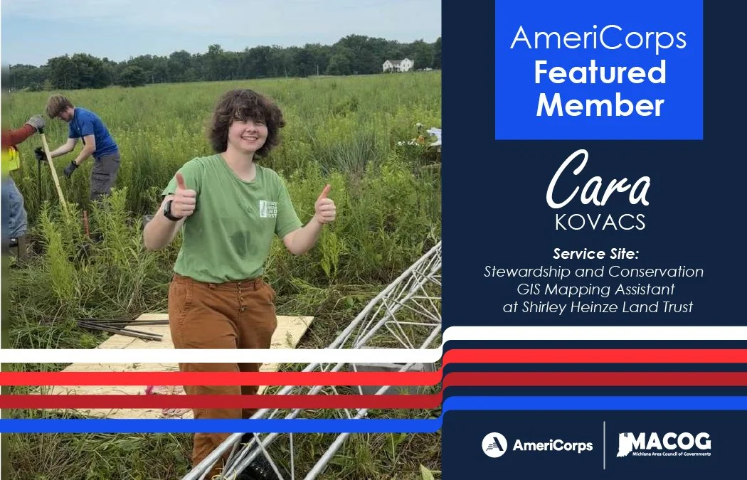 Cara standing in a field, smiling giving two thumbs up.