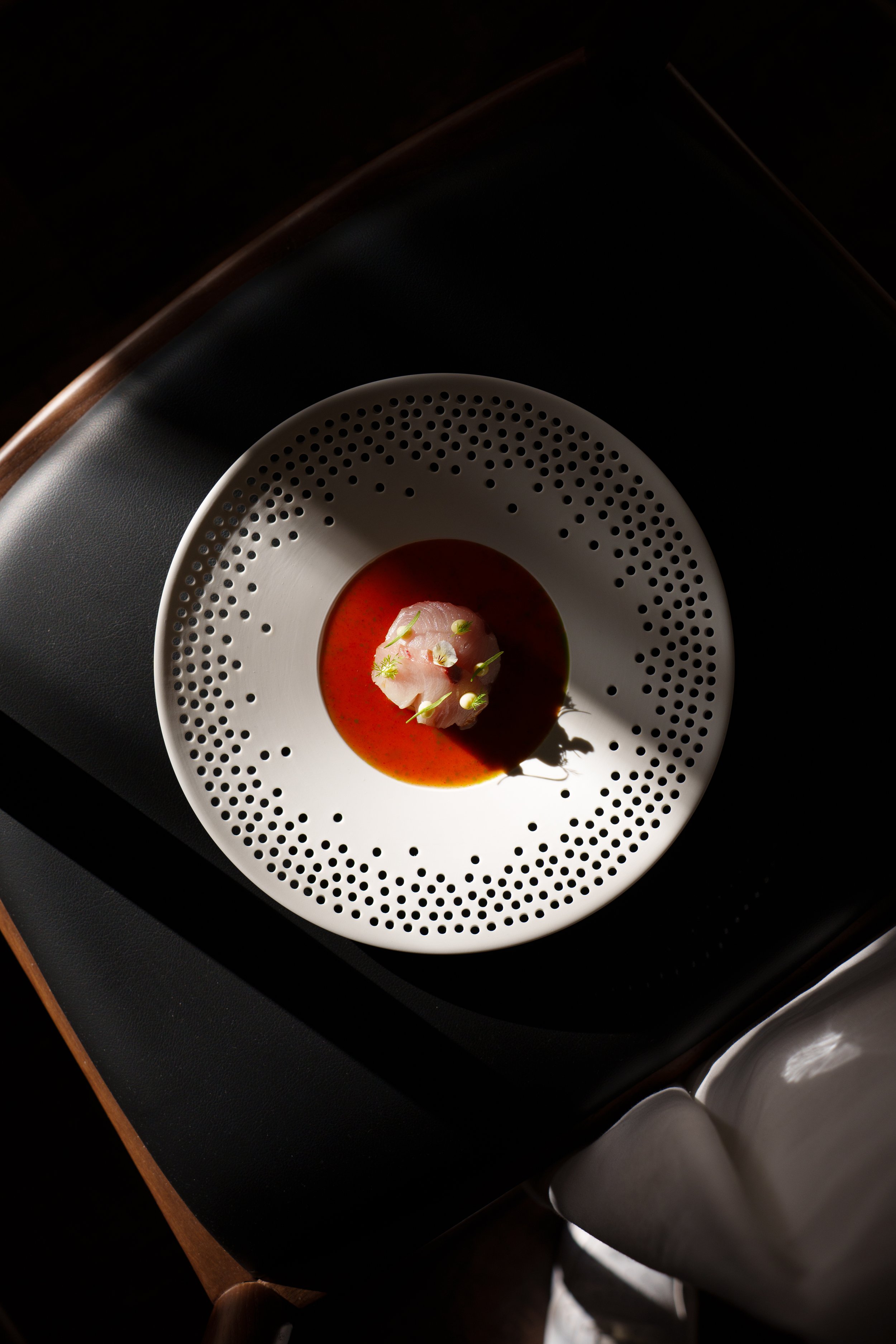 A fine dining dish with fish and bouillon