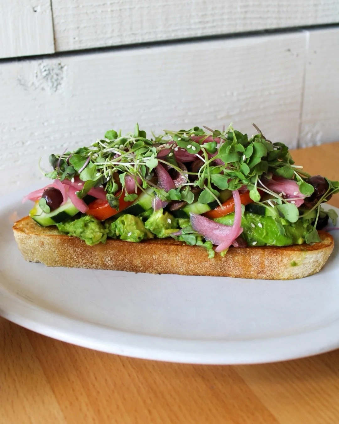 the farmer&rsquo;s daughter 🌿

for our plant-based babes, toasted sourdough layered with smashed avocado, tomato, cucumber, pickled red onion, greek olive medley, microgreens, EVOO + sea salt.

fresh, colorful, simple, and very much doing what she n