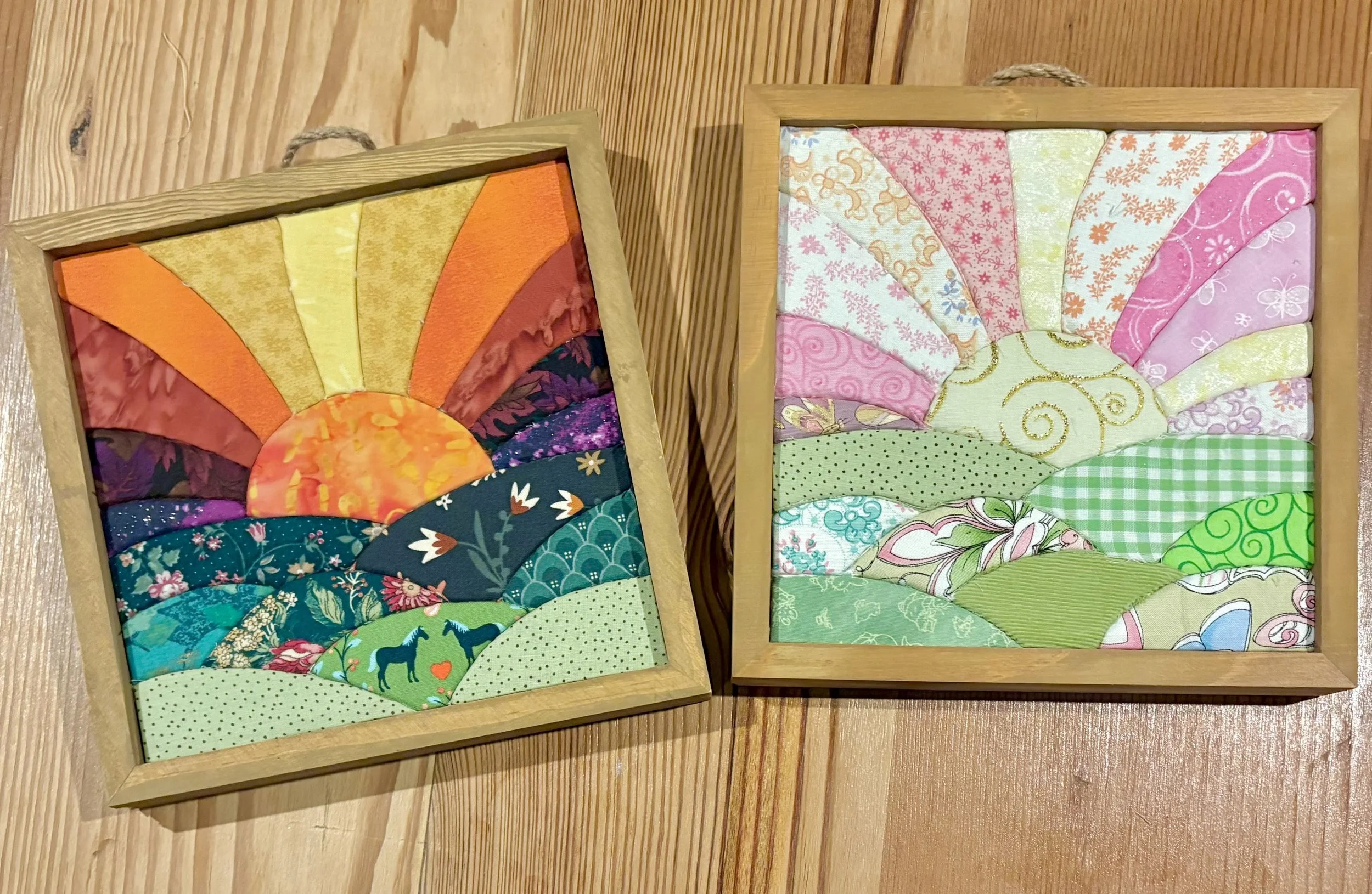 Two framed kinusaiga fabric art projects with colorful botanical designs