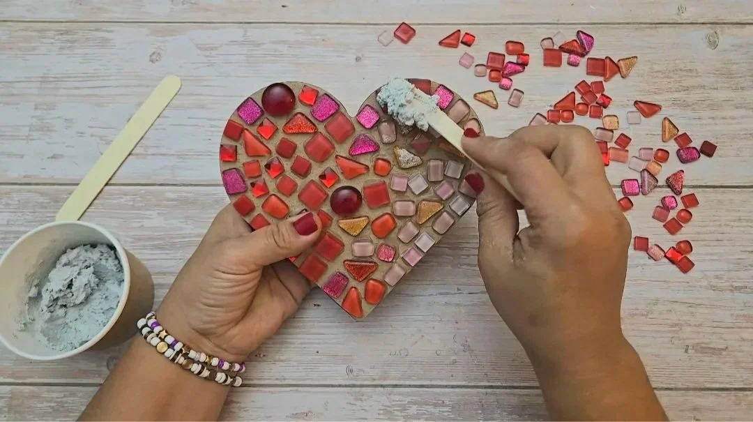 Crafter making heart mosaic with red tiles