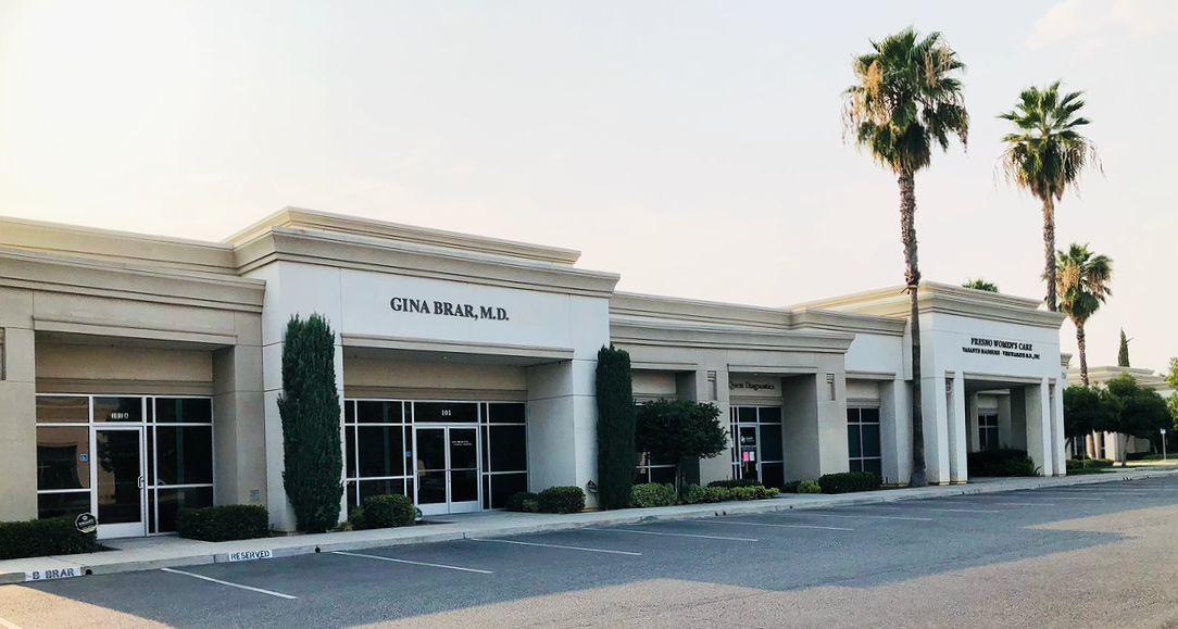 Premier Medical Office building featuring signs for Gina Brar, M.D., with palm trees in front.