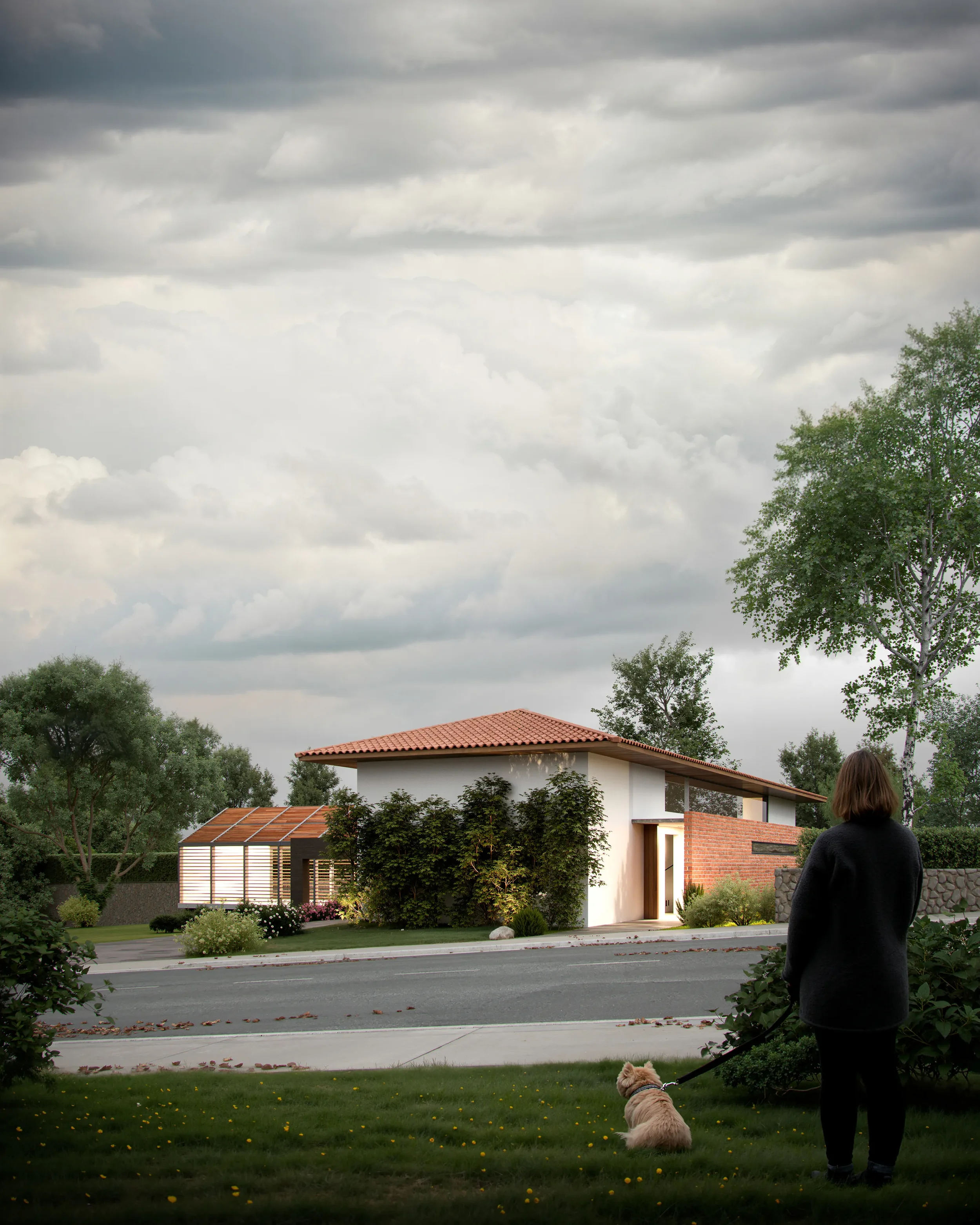 A woman walking her dog on a grassy lawn in front of a modern house with a brick and white exterior, surrounded by greenery, under a cloudy sky.