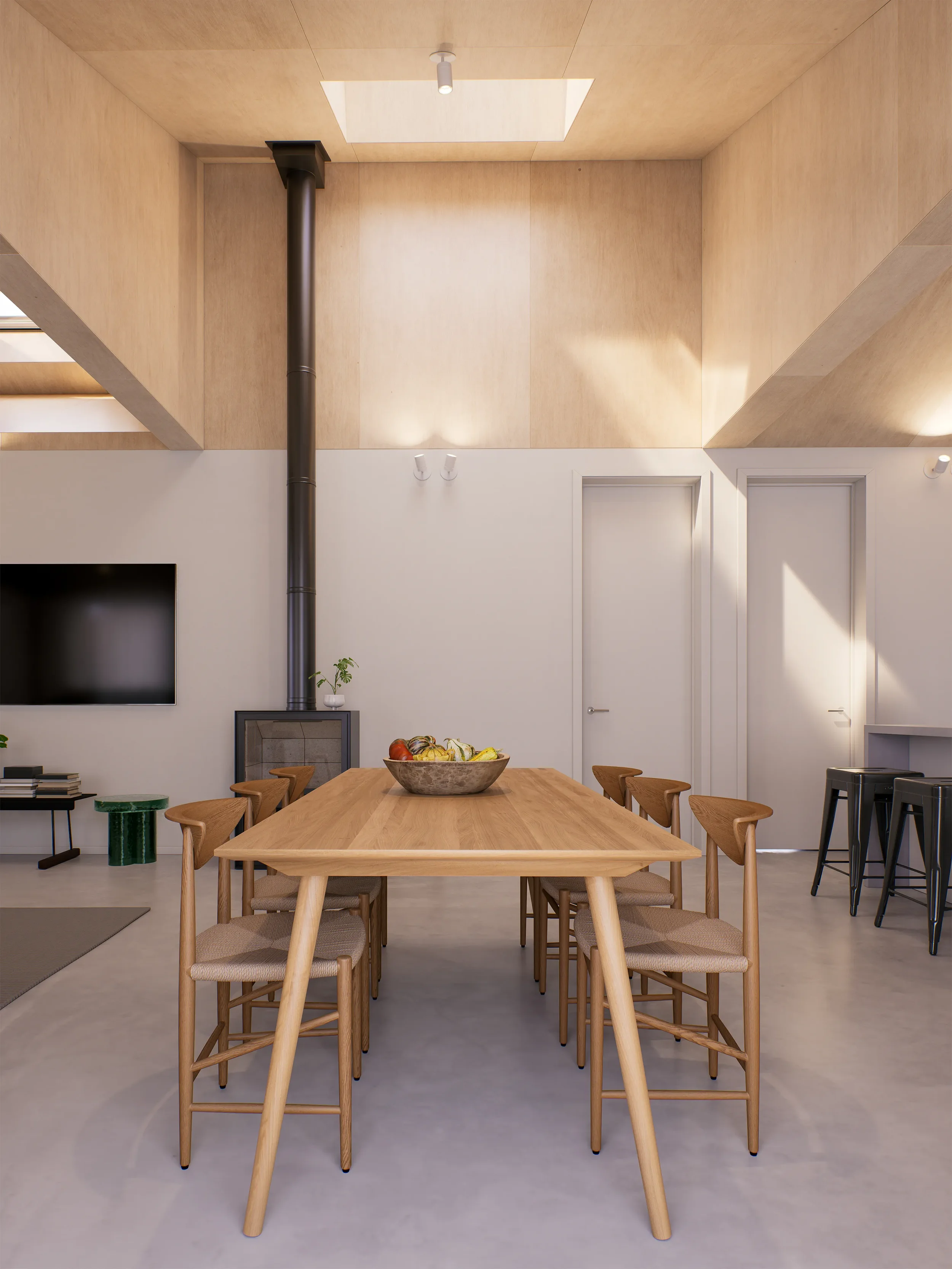 Modern dining room with a wooden table and chairs, a bowl of fruit, a wall-mounted TV, a fireplace, and a high ceiling with skylights.