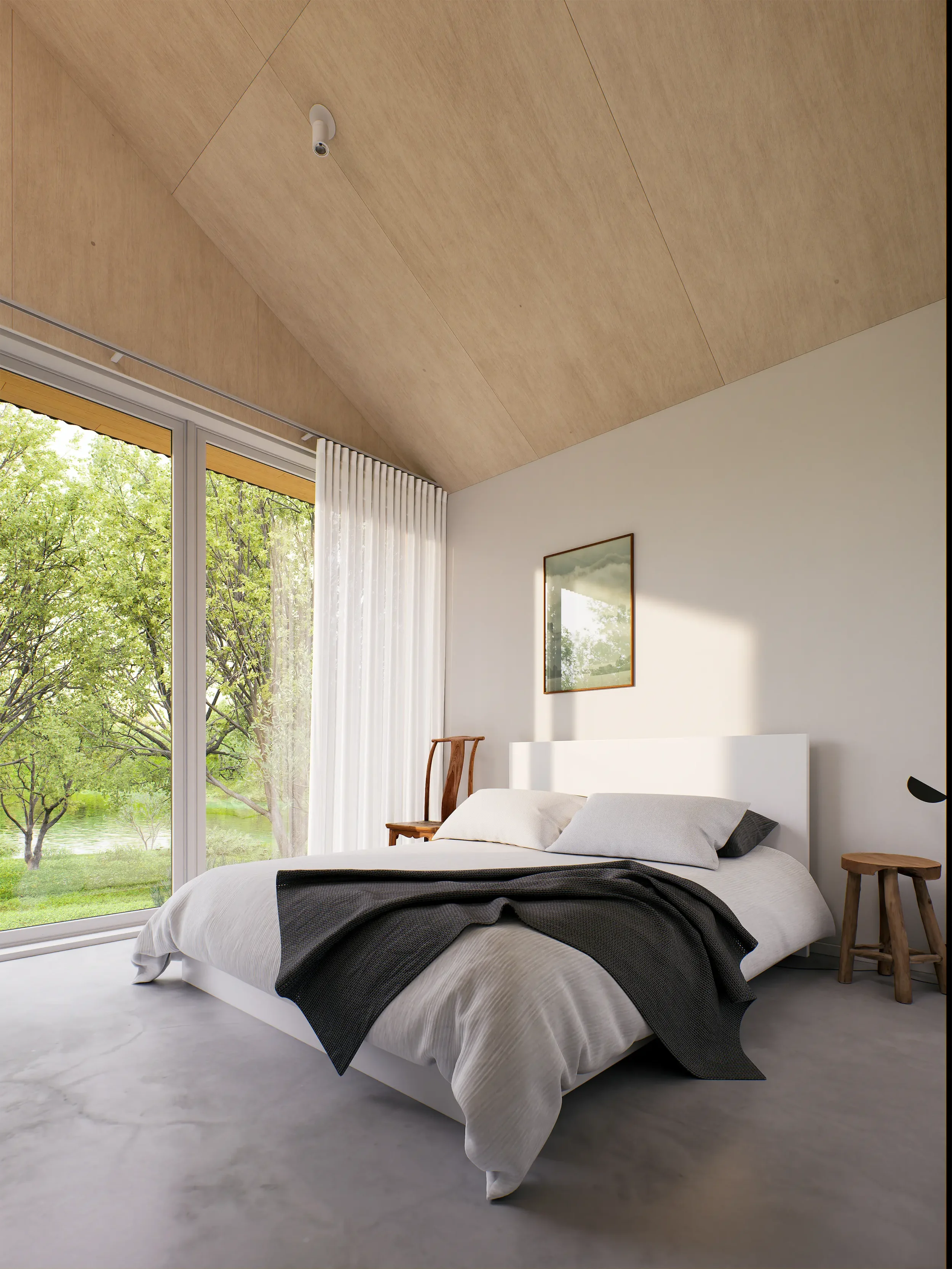 Modern bedroom with a large window showing green trees outside, white walls, a white bed with gray and black bedding, a wooden chair, a small wooden stool, and a framed mirror on the wall.