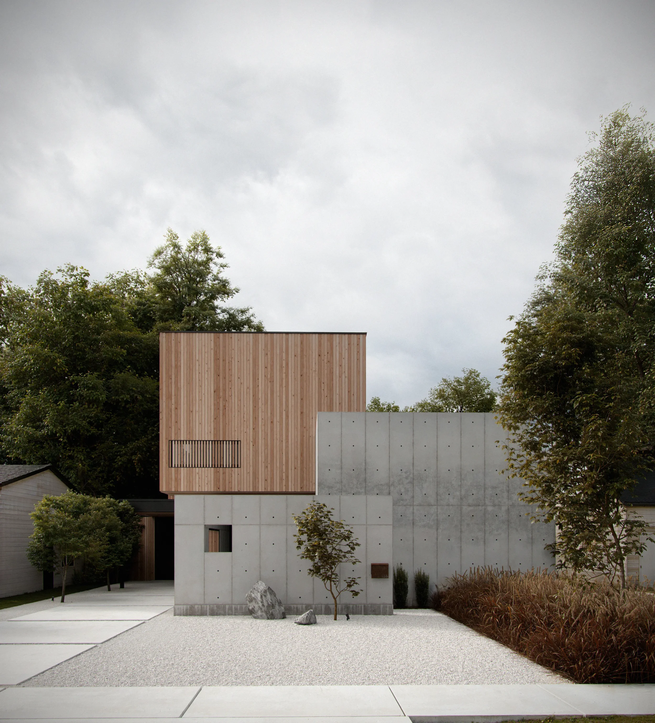Modern house with concrete and wooden exterior, surrounded by trees and landscaping, under cloudy sky.