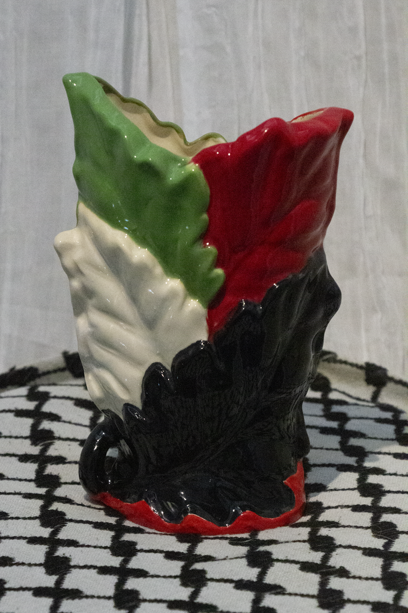 "Vase 12", a small ceramic vase of leaves painted in green, black, and red to represent the Palestinian flag