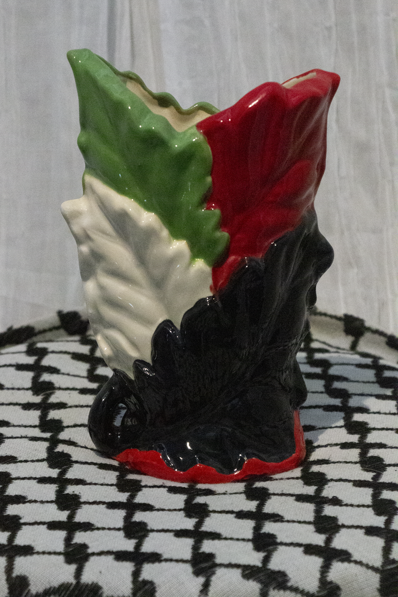 "Vase 10", a small ceramic vase of leaves painted in green, black, and red to represent the Palestinian flag