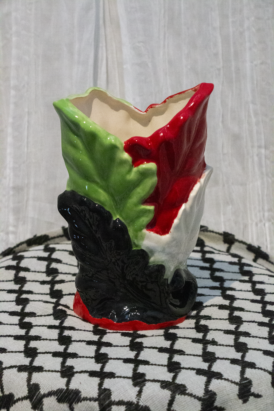 "Vase 8", a small ceramic vase of leaves painted in green, black, and red to represent the Palestinian flag